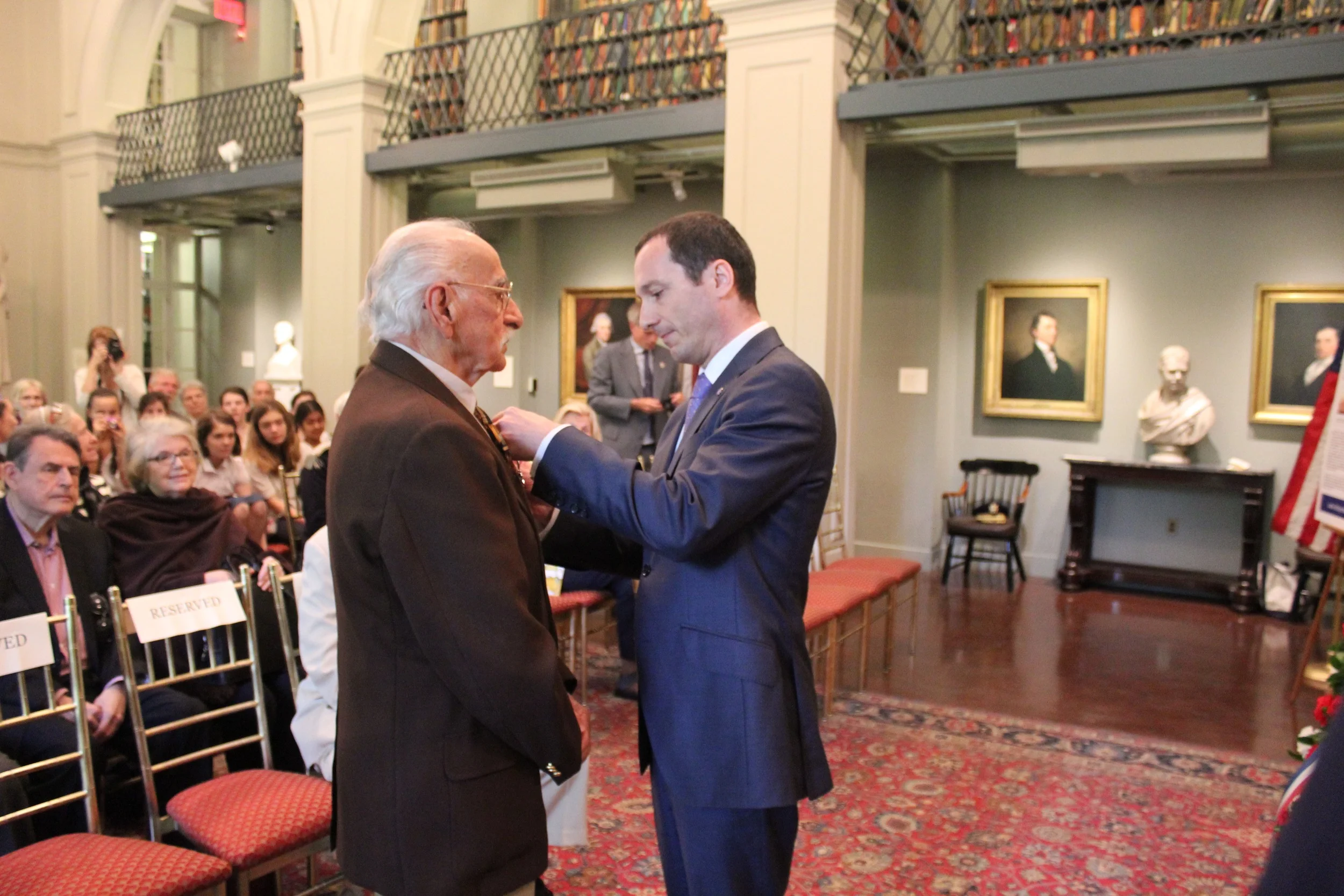 The Consul pins the Legion of Honor Medal on Mr. Filios