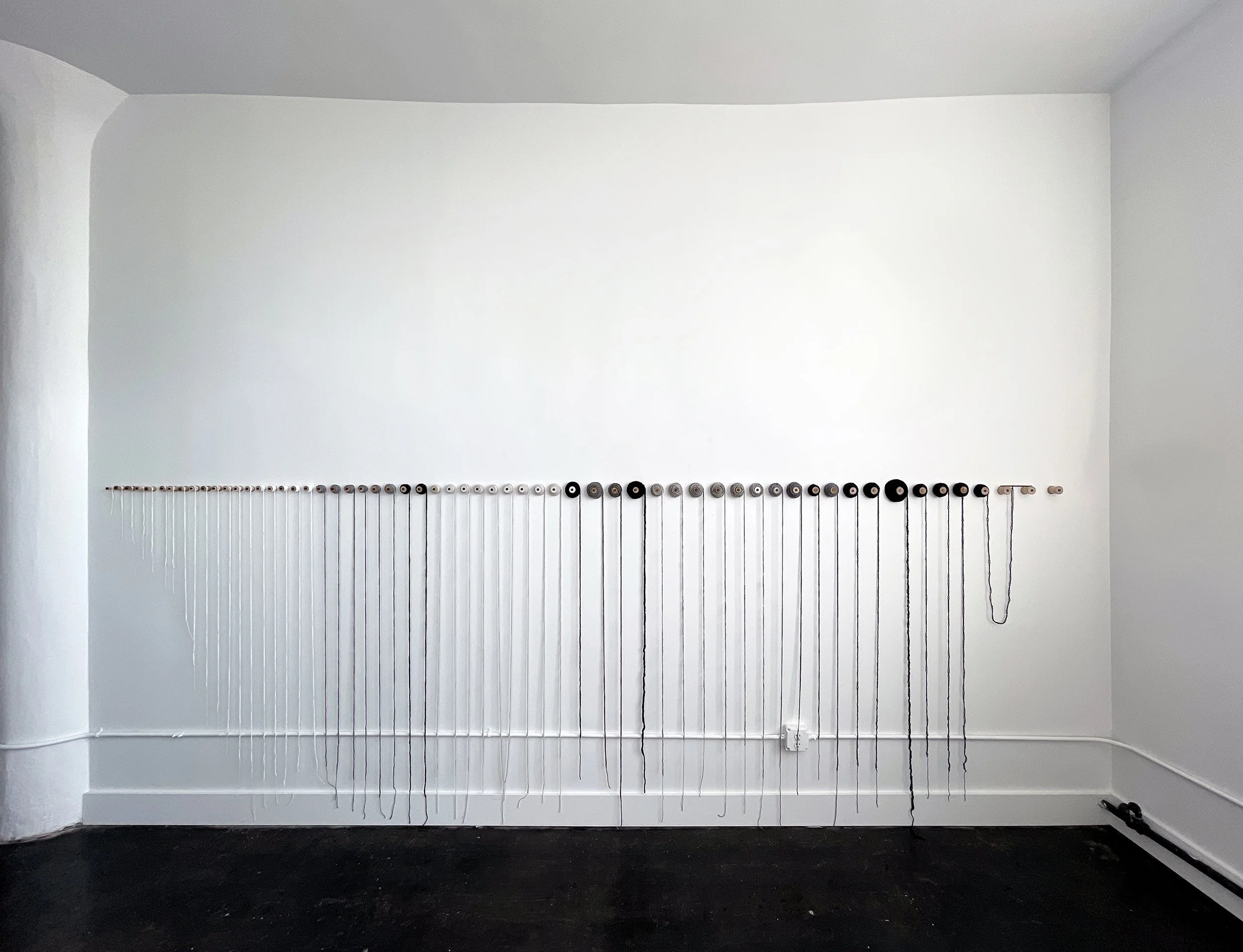 2023 installation, crocheted chain lengths on vintage wooden spools