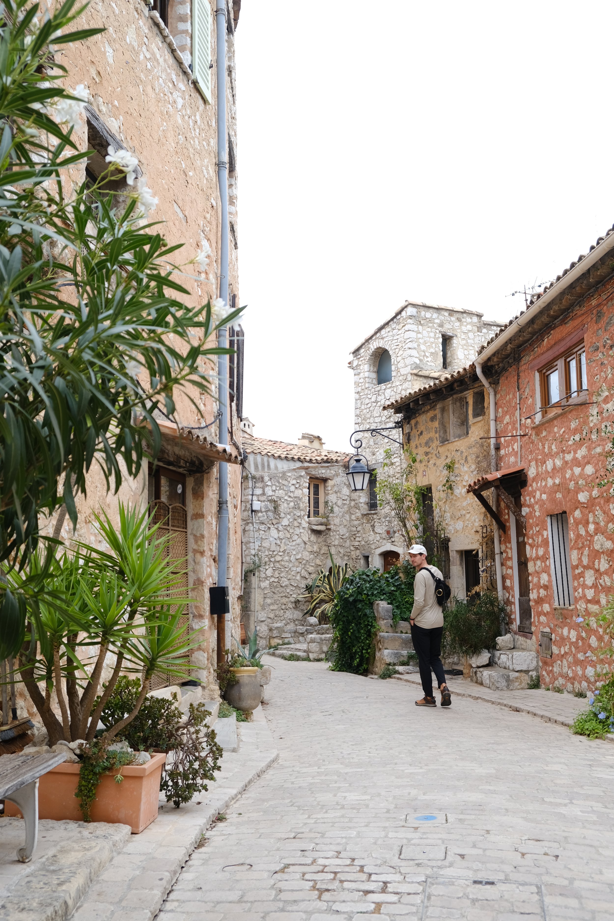 Man looking back over his shoulder as he walks down the streets of Tourettes Sur Loup in the South of France, Cote d'Azure.