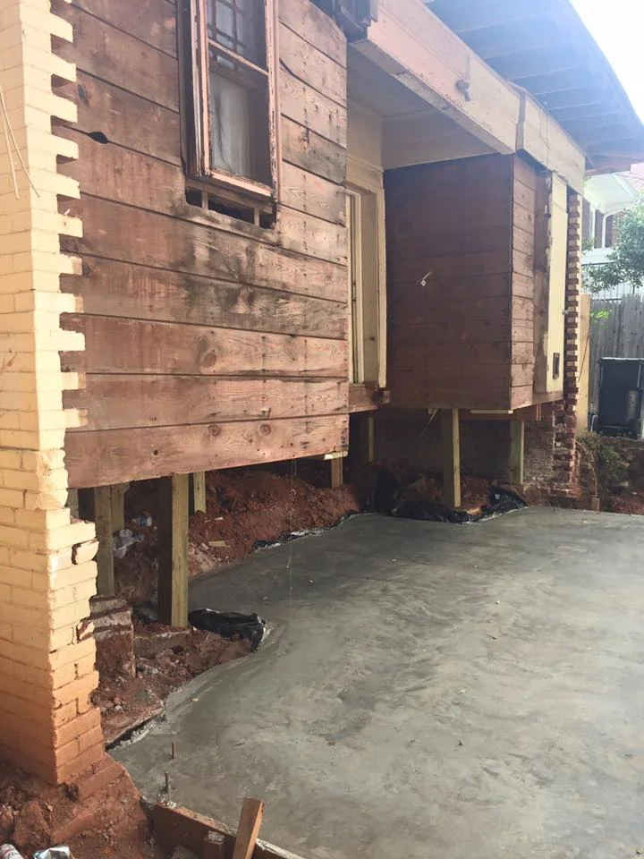 Photo: Red Door Investments. New foundation followed existing load-bearing walls. The historic brick foundation is visible at the bottom of the image.