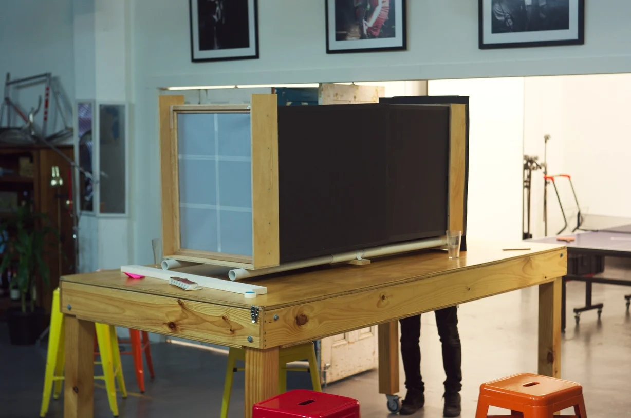 Our half finished 20×24 camera sitting on a table on wheels (makes a nice stand!), sitting ready to test out the lens…