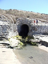 The exit tunnel for San Vicente Creek at the beach. The creek flows directly into the ocean behind the photographer. Before the construction of the cement plant, and this railroad rampart/tunnel system, San Vicente Creek was considered to be the best trout-fishing stream in Santa Cruz County. What happened to the creeks?