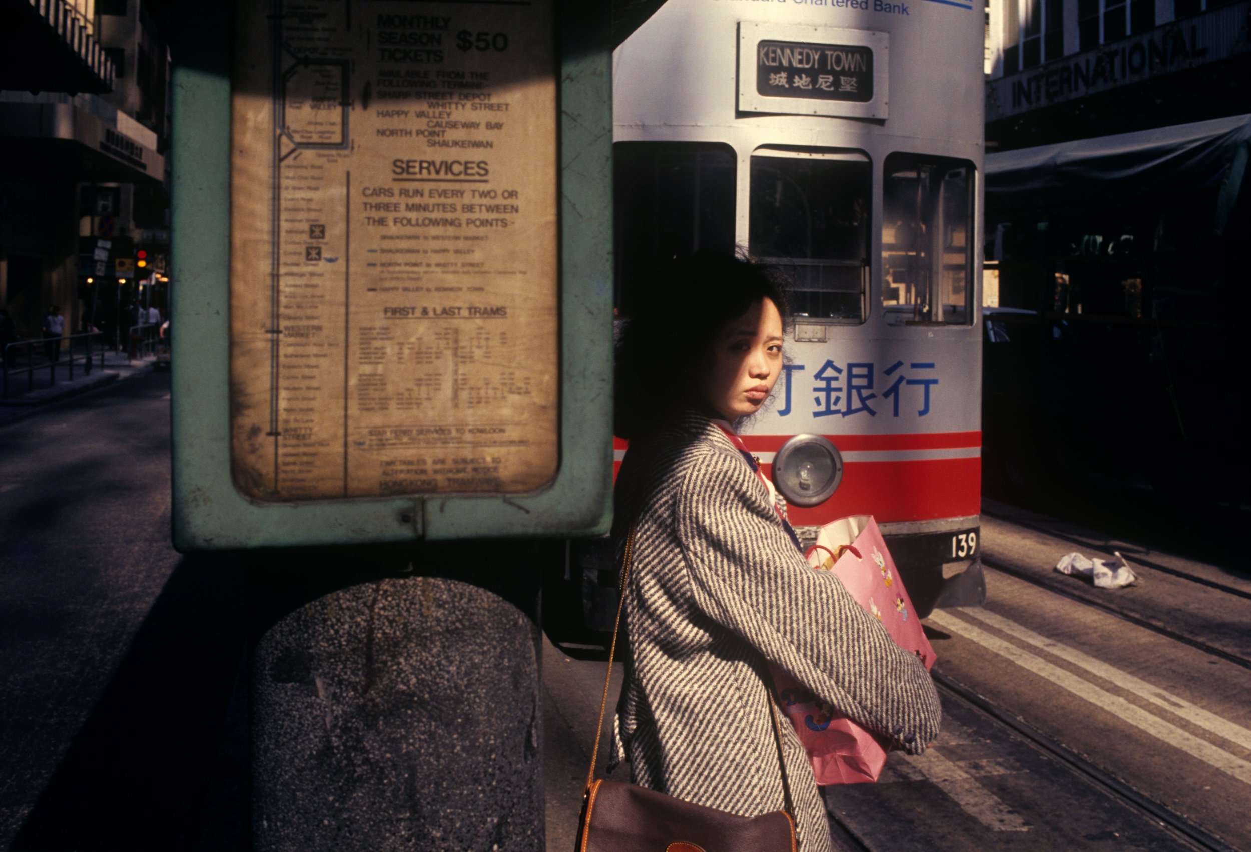 Greg Girard, Woman at tram stop, Central, Hong Kong 1985