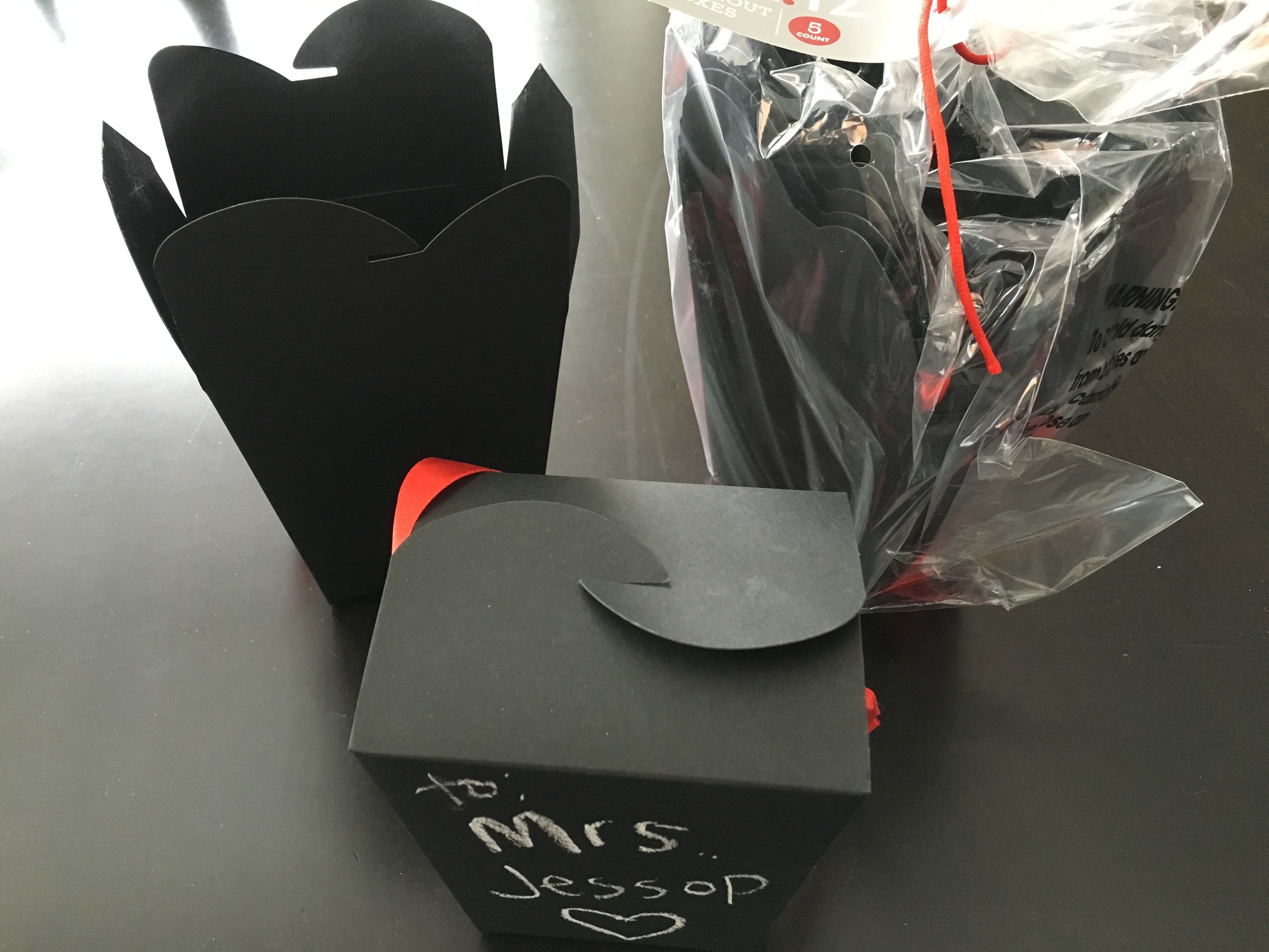 Scored these black take out containers with chalk at Target during the After Christmas sale. Five containers for $2.50. They had red ties and since we live in MN, it's not a seasonal faux pas to have a snow flake on the gift tag for Valentine's Day. So we'll turn them into the gift containers for the socks for the teachers with chalk written messages from the kids. 
