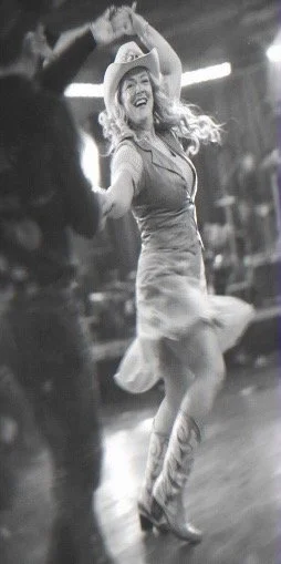 Black and white photo of dance instructor Beth Coffey leading the Texas Two-Step