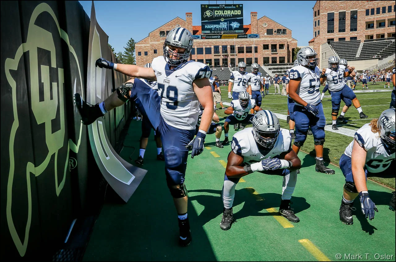 UNH offensive lineman Noah Robison (#79) uses the CU logo to limber up as he and his teammates prepare for the start of their game against the University of Colorado Saturday, Sep. 15, 2018 at Folsom Field in Boulder.