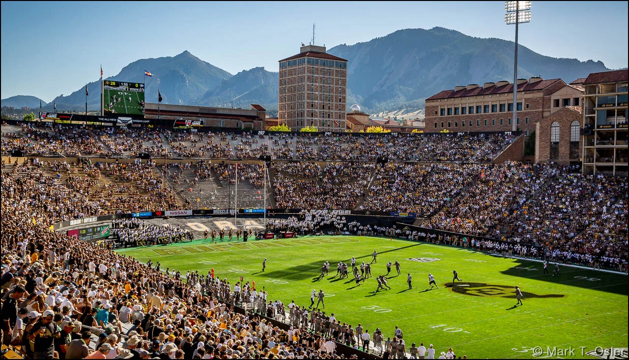 The UNH offense battles against the CU defense on the New Hampshire side of the field in the first half of UNH’s game against CU in scenic Boulder, CO, at the base the Rocky Mountains. Temperatures were in the 90s at game time.