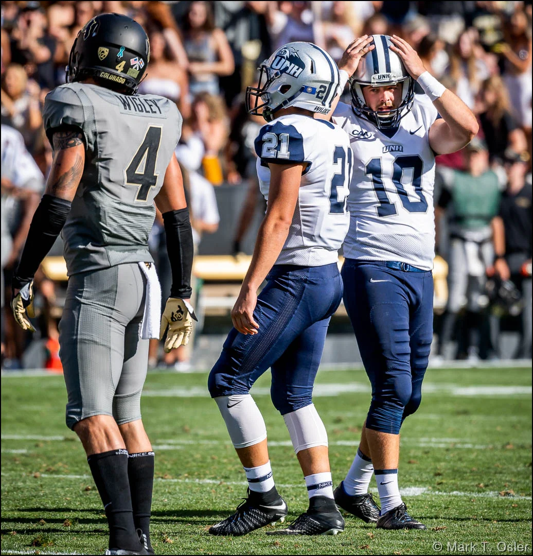 UNH field goal holder Drew Sanborn (#10) holds his head in disbelief after kicker Jason Hughes’ (#21) kick bounced off, and outside of, the right upright for an unsuccessful field goal attempt in the second quarter.