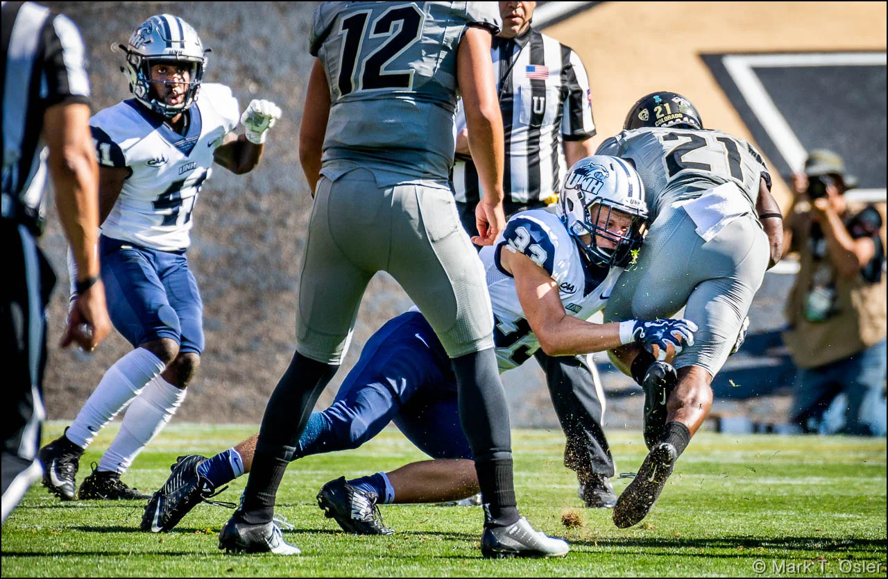 UNH safety Evan Horn (#33) takes down CU tailback Kyle Evans (#21) after one of Evans’ three consecutive rushing gains early in the second quarter. UNH cornerback Alonzo Addae (#41, left) closes in on play.