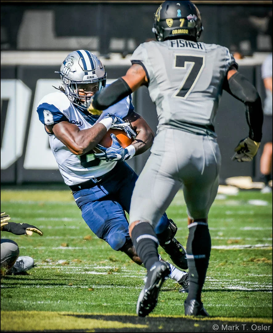 UNH running back Trevon Bryant (#8) evades CU safety Nick Fisher (#7) for a 4-yard gain in the first quarter.
