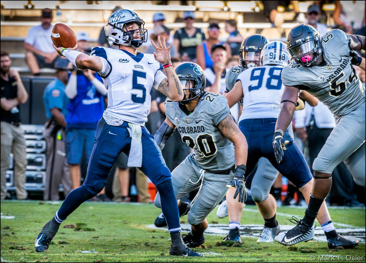 Under pressure by CU linebacker Drew Lewis (#20) and defensive end Terrance Lang (#54), UNH quarterback Christian Lupoli (#5) throws a 71-yard touchdown pass to wide receiver Neil O’Connor (not shown) in the third quarter to make the score 38-14, following the extra point. Lupoli completed 14 of his 24 passes for 133 yards in his first career start for the Wildcats.