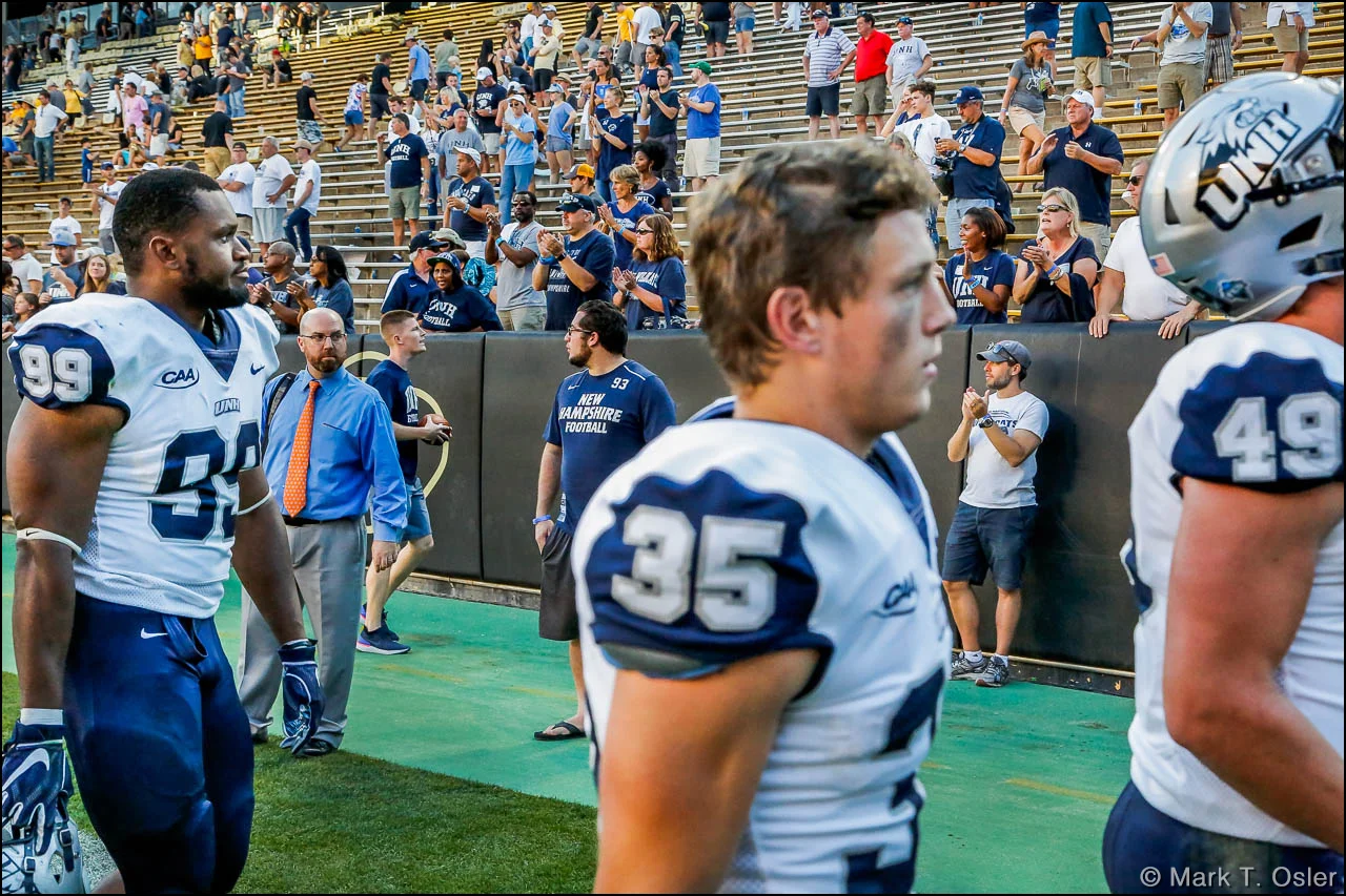 UNH faithful stayed to the bitter end to cheer the efforts of their Wildcat football team as players leave the field following the team’s 45-14 loss to the University of Colorado Saturday, Sep. 15, 2018 in Boulder, CO. Leaving the field (l. to r.) are UNH defensive end Brian Carter (#99), wide receiver Sean Coyne (#35) and tight end Gunner Gibson (#49).