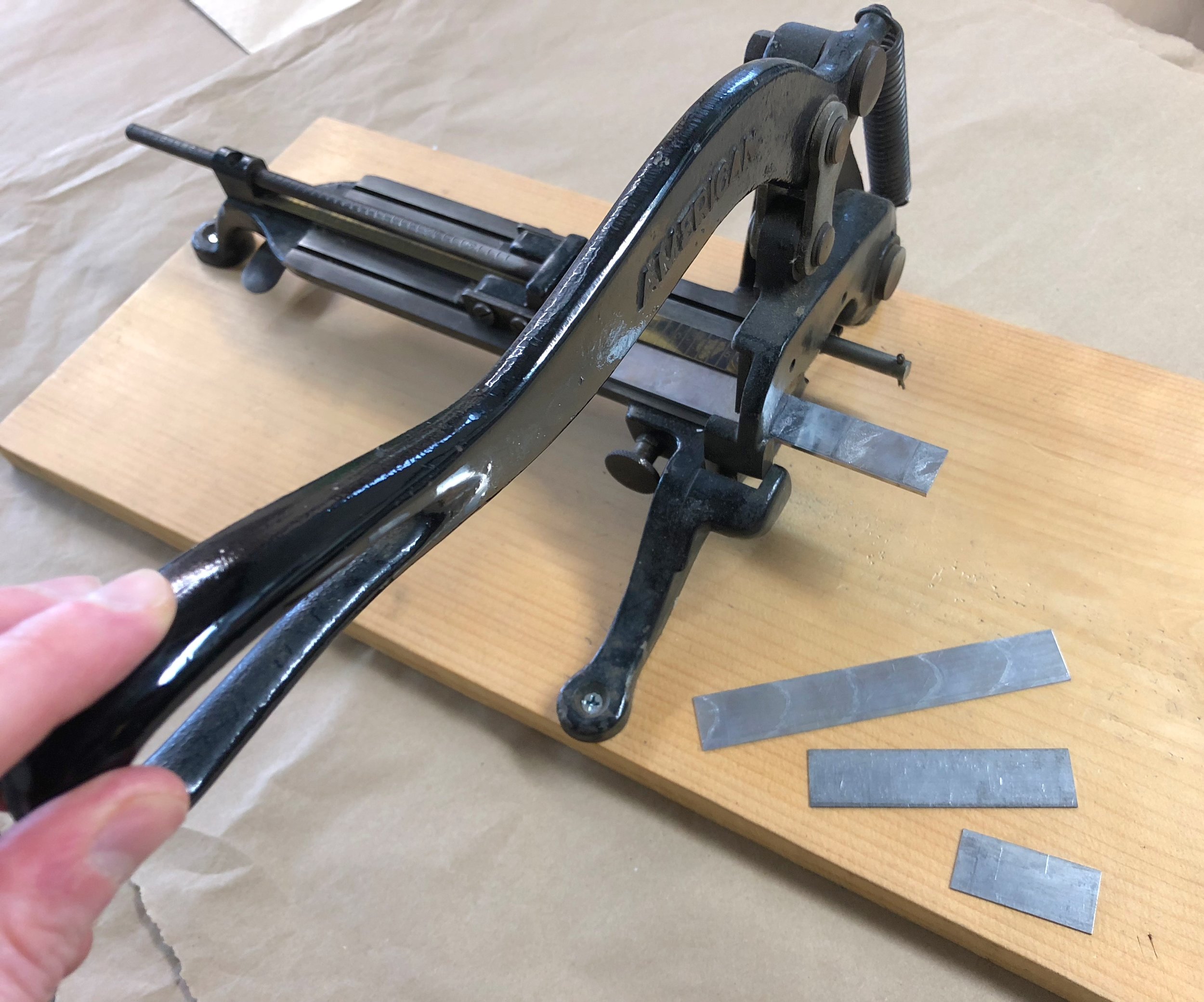 A vintage "slug cutter," to cut metal strip material to the desired length.