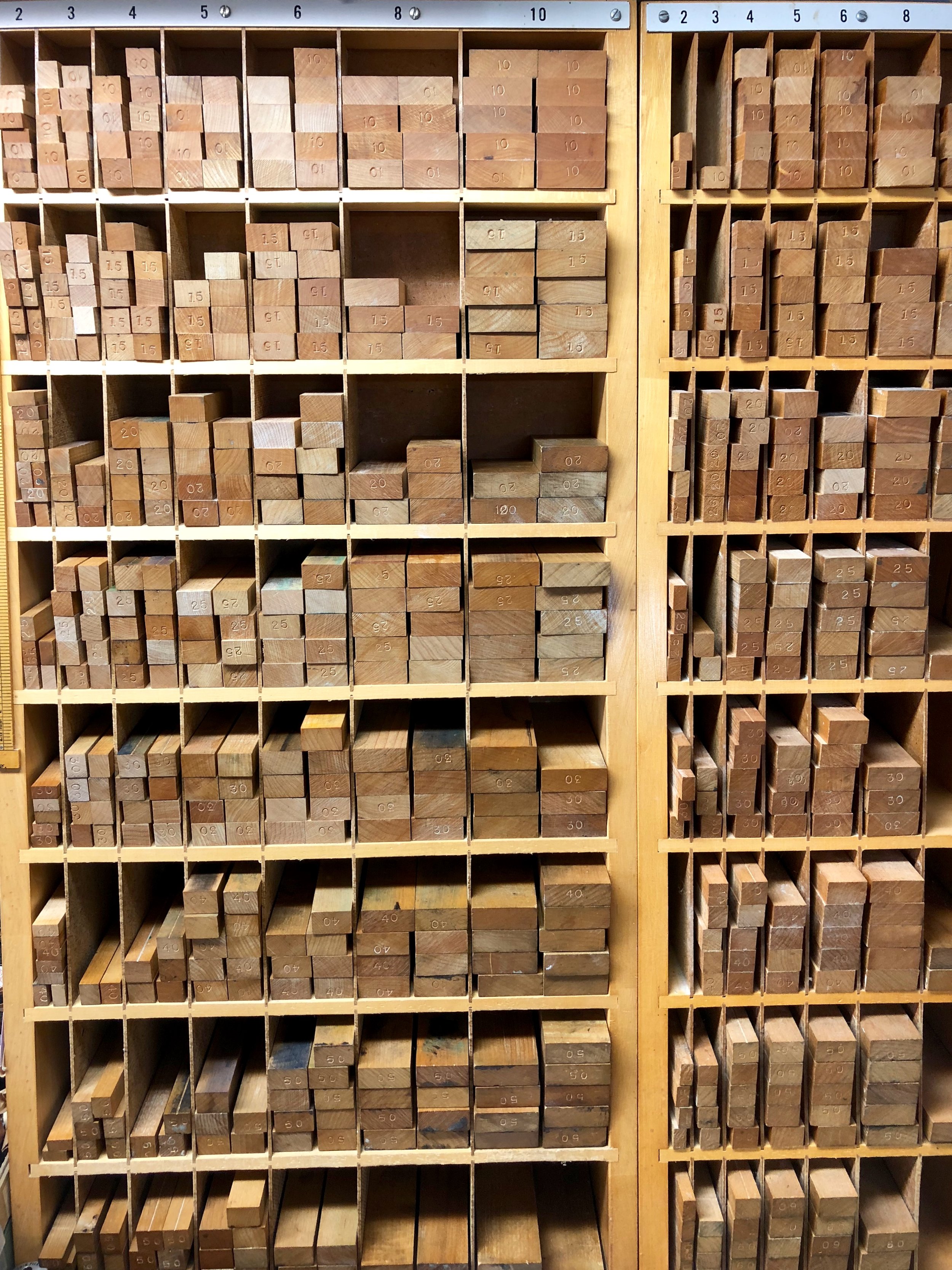 Racks of wood furniture at St Brigid Press, ordered according to length and width.