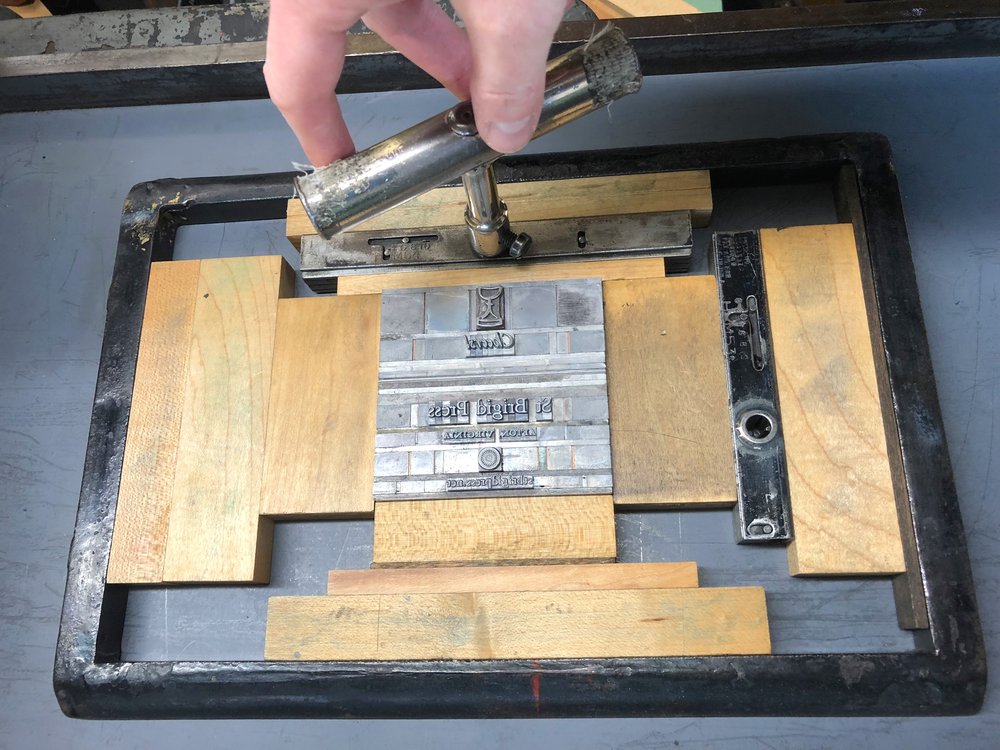 Turning the quoins, or locks, to tighten the whole forme in the chase.