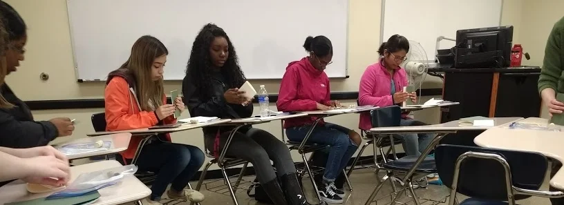 "Women in Literature" students hand-sewing their first notebooks.