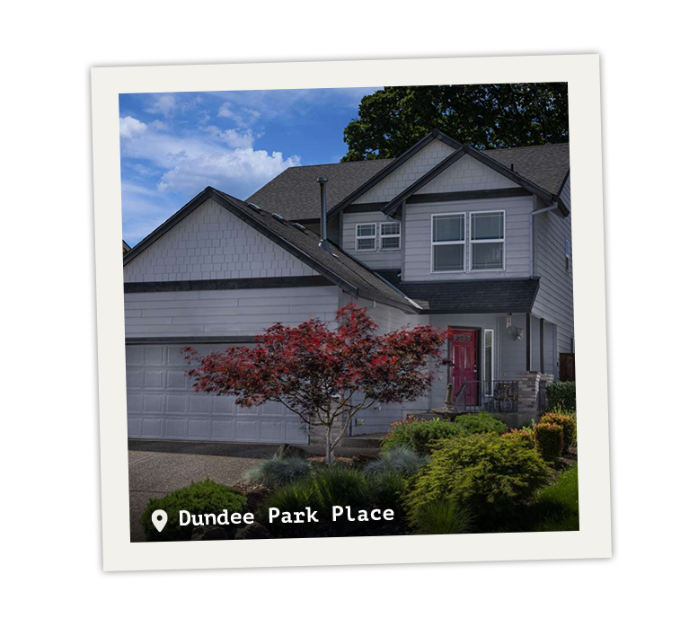 Two story house with lush landscaping in front.