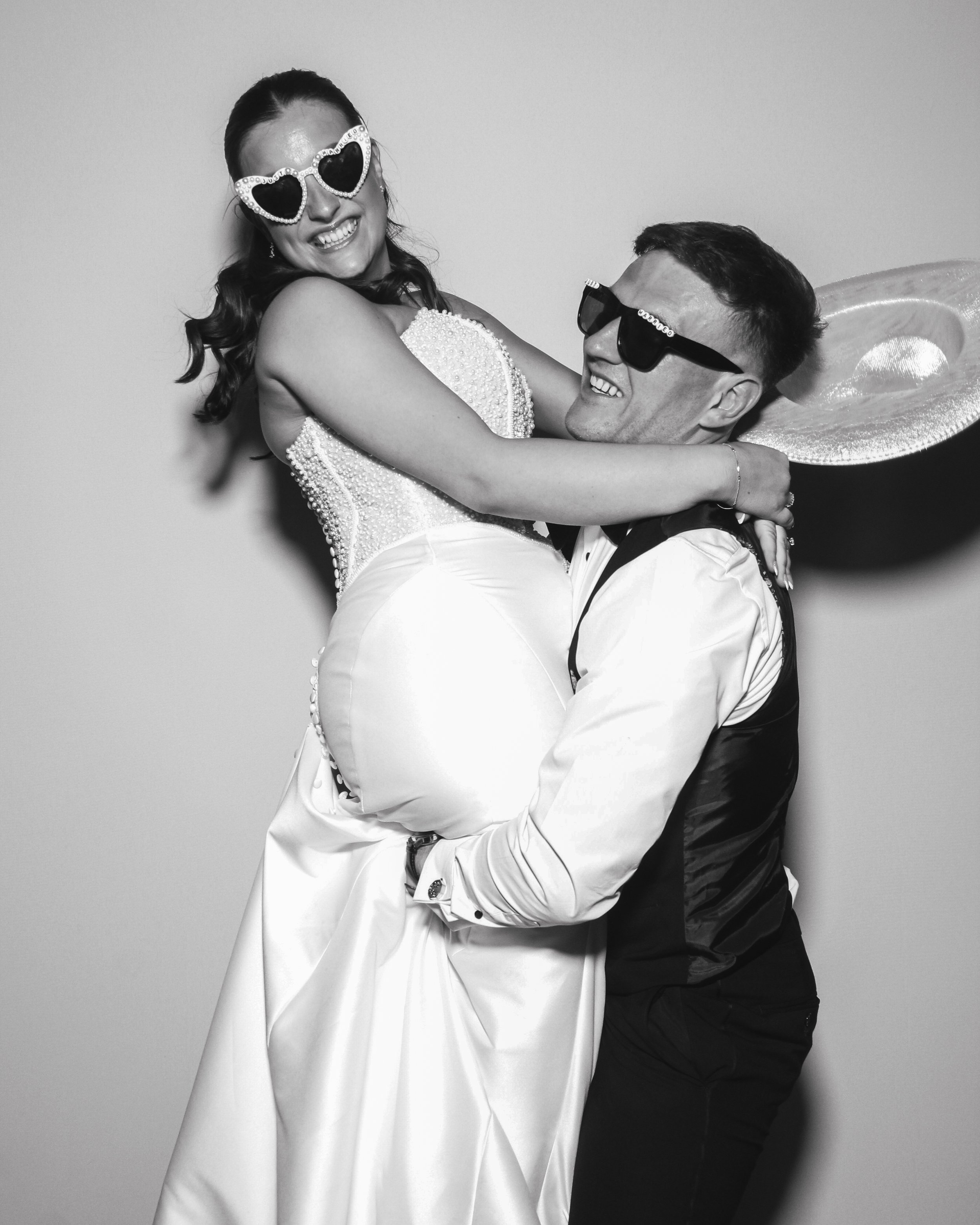 Bride and groom posing for a photo booth picture at Hazel Gap Barn wedding venue in Nottinghamshire with Bliss Booth's ICON Photo Booth.