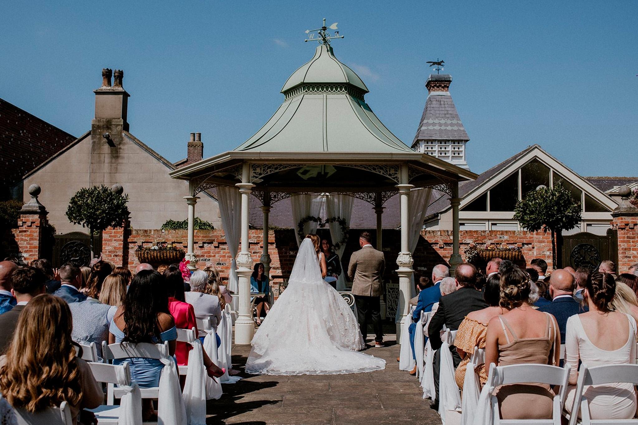 Outdoor wedding ceremony at Mount Pleasant Hotel, Doncaster under the green gazebo with guests seated.