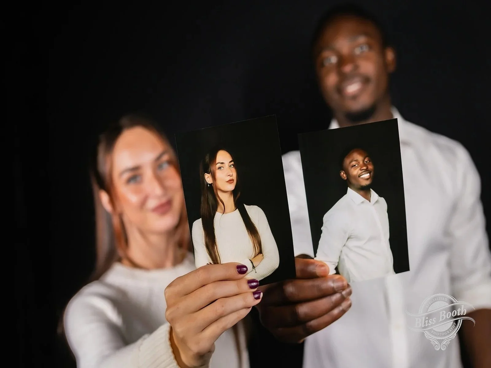 Guests holding printed professional headshots captured at a corporate event
