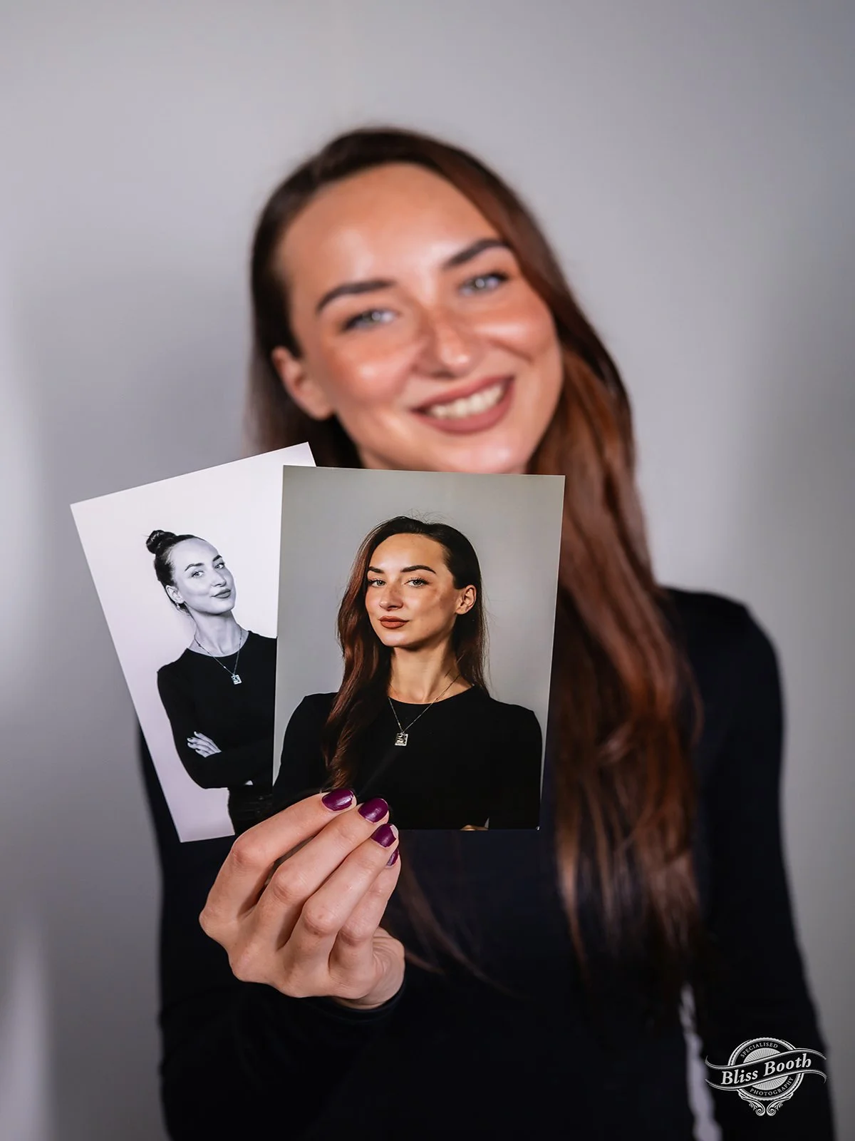 Guests holding printed professional headshots captured at a corporate event
