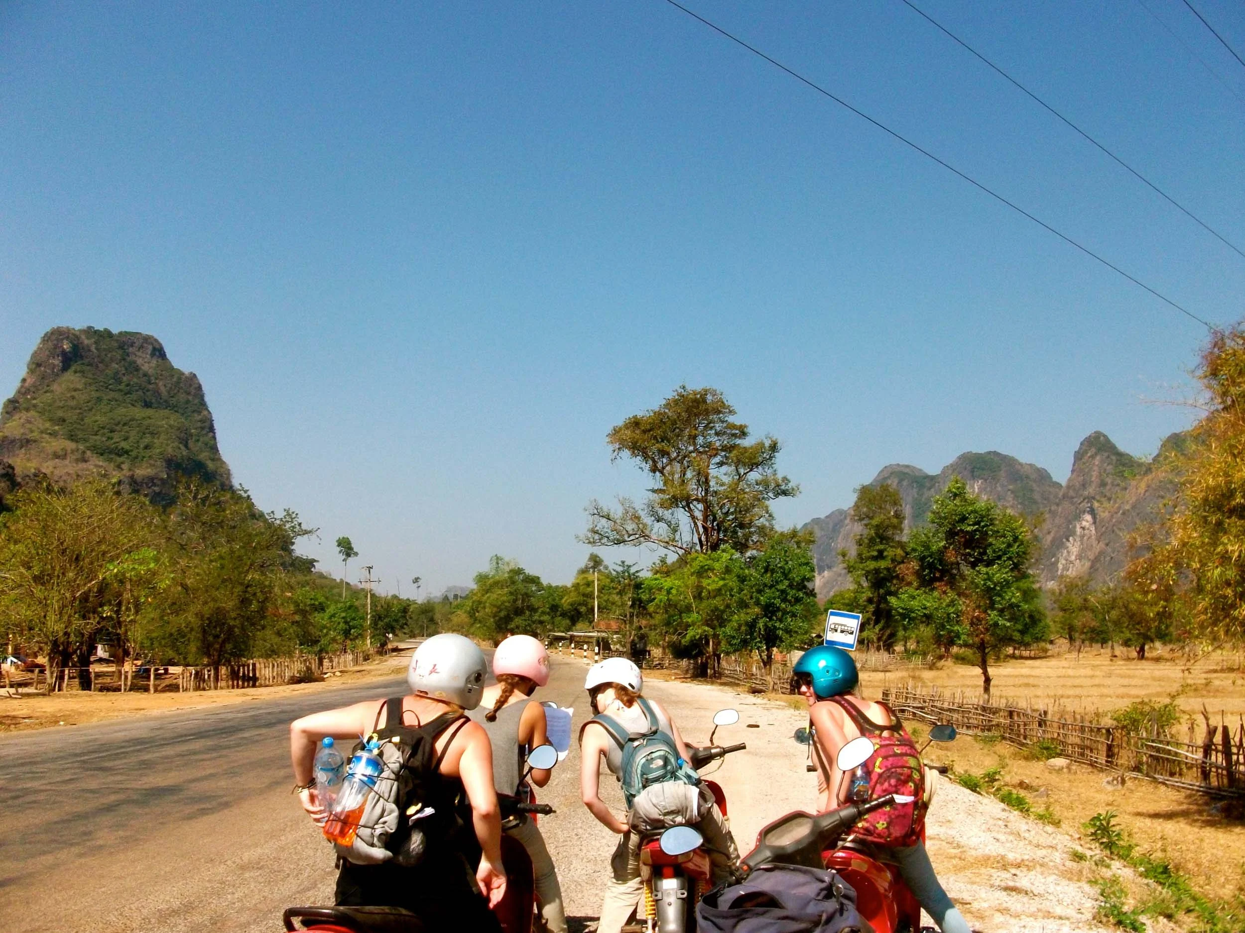 4 women consulting their map while motorbiking 'The Loop" trek in Laos.