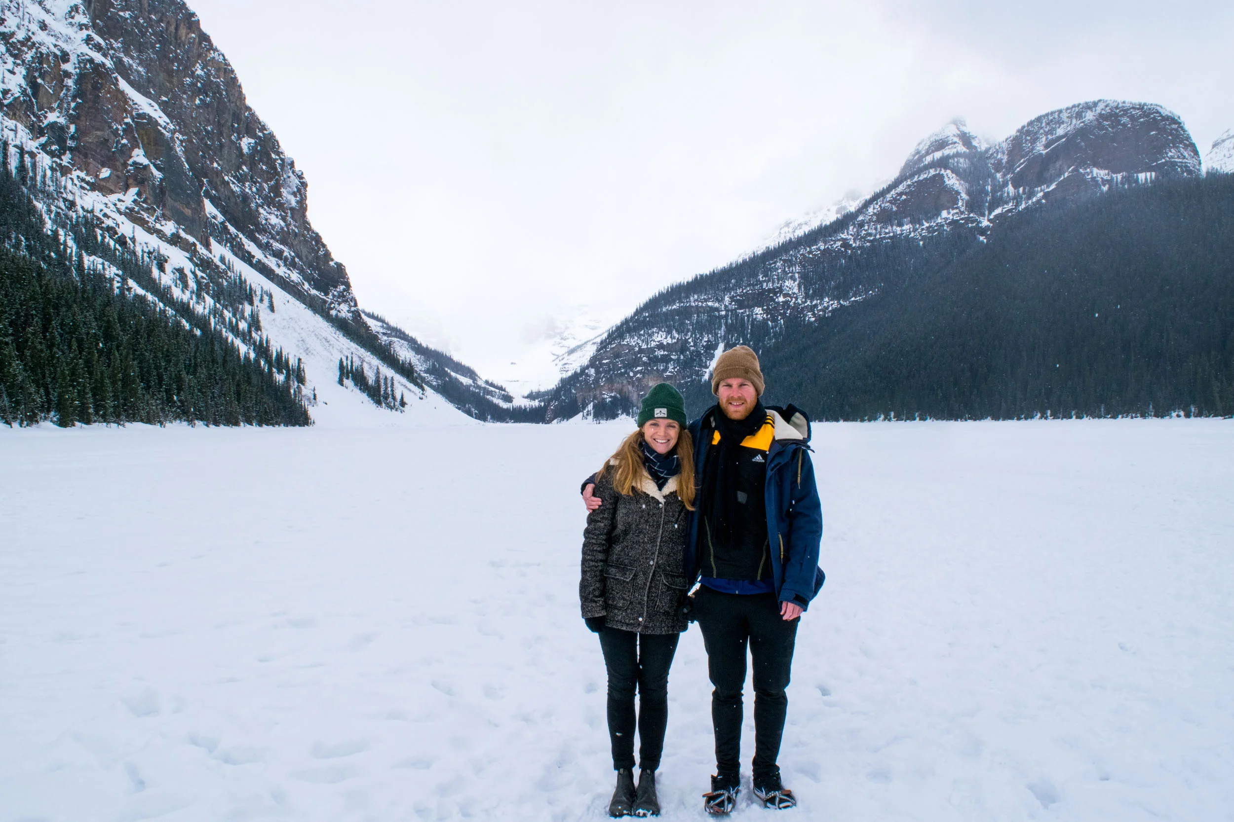 Couple stood on a frozen Lake Louise, near Banff, Alberta, Canada.