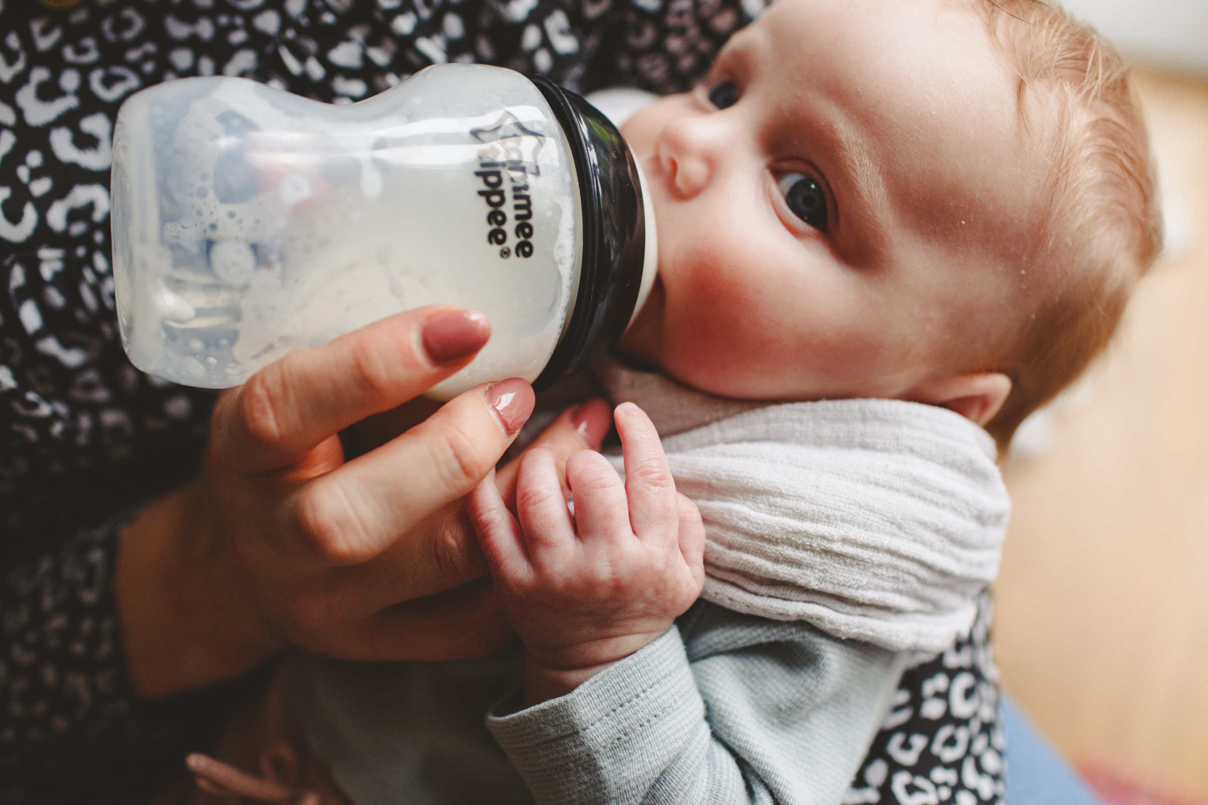 Baby drinking from bottle during family photoshoot