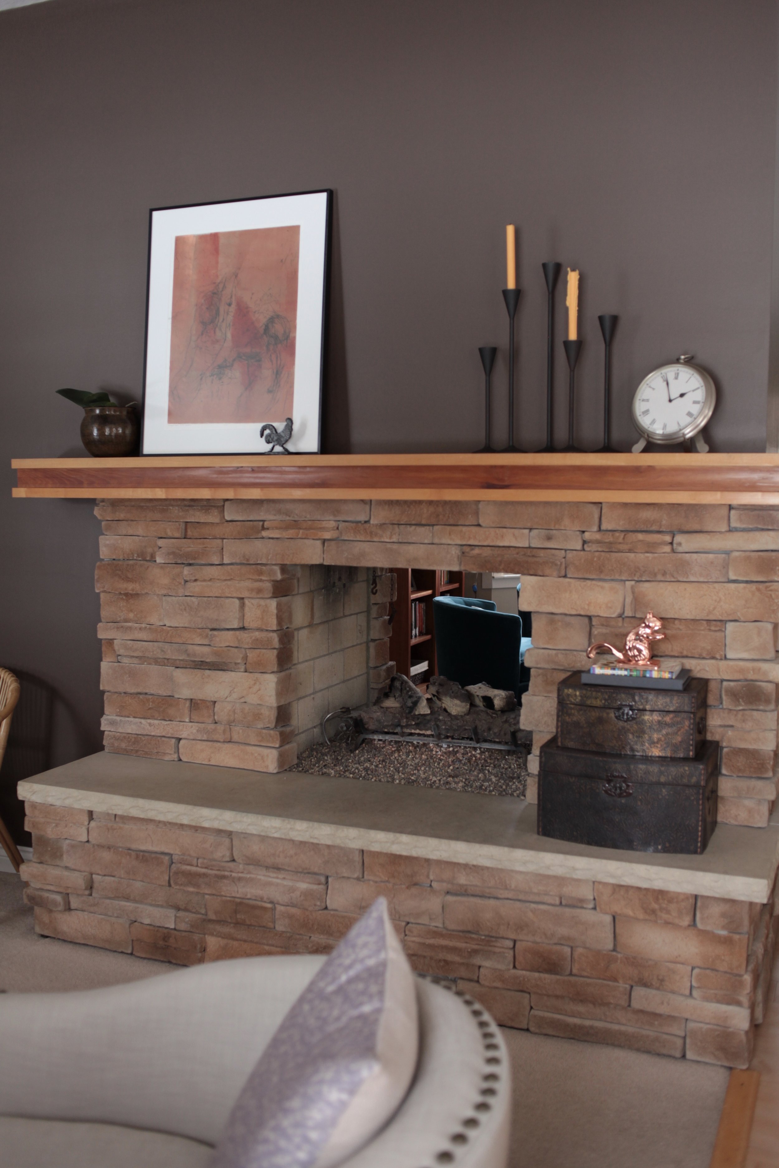 Styled large fireplace with modern black candlesticks and orange art.jpeg