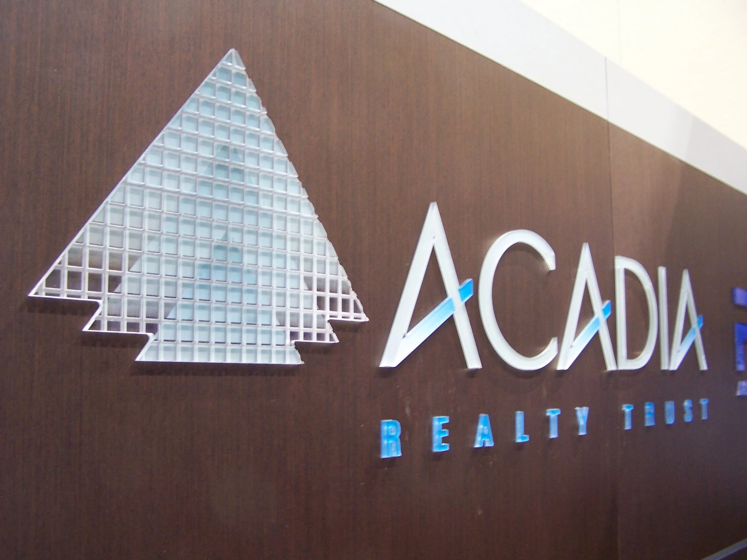 Acadia's logo, made of back-printed acrylic with CNC cut grooves.