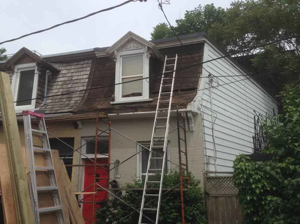 Old shingles removed and bad eaves. One board removed and no insulation in the walls was found as we had guessed.