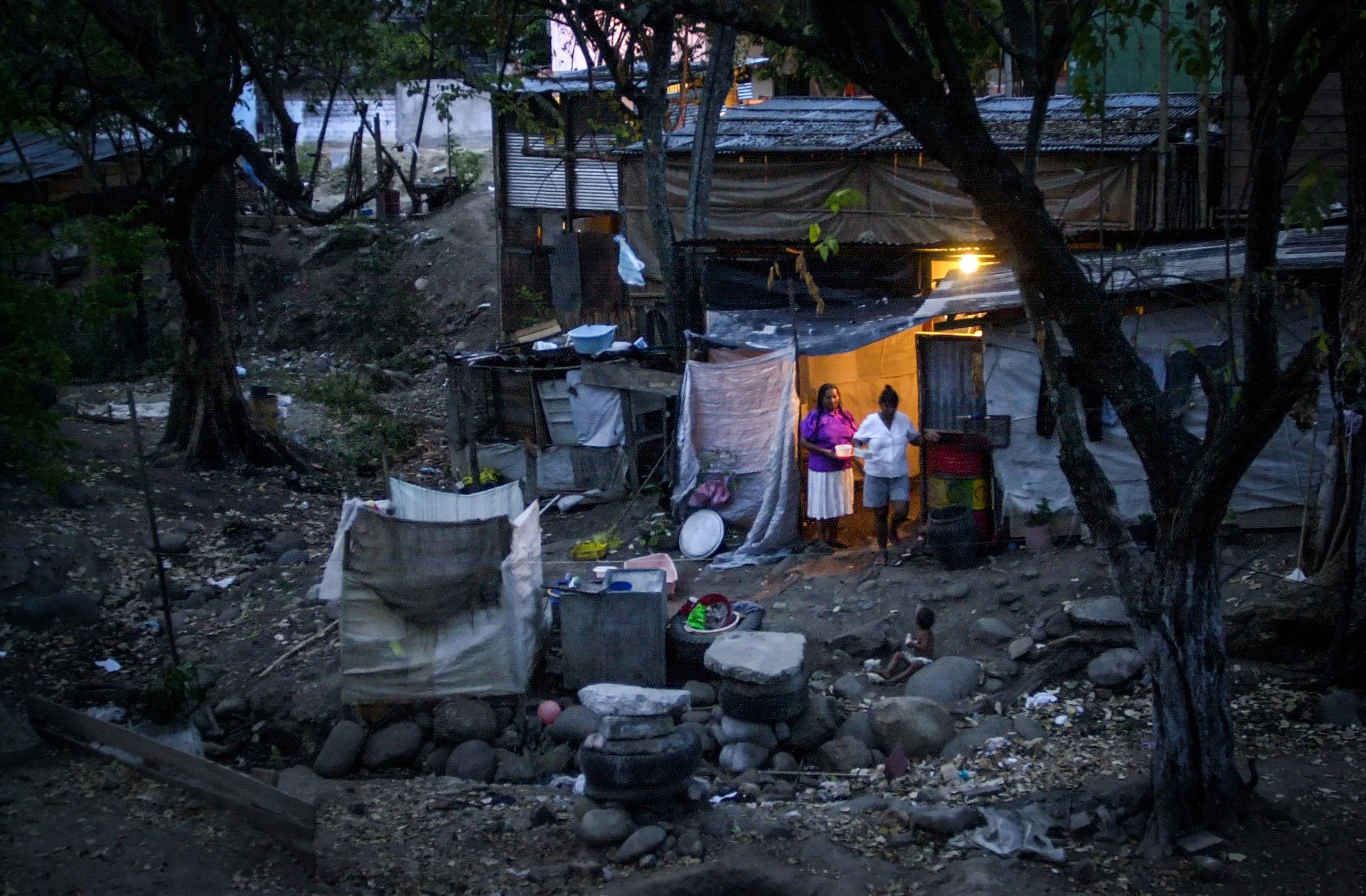 Night falls on the shanty home in the barrio Chicala outside of Neiva, Colombia, where more than 200  families lived in houses built from construction scraps.
