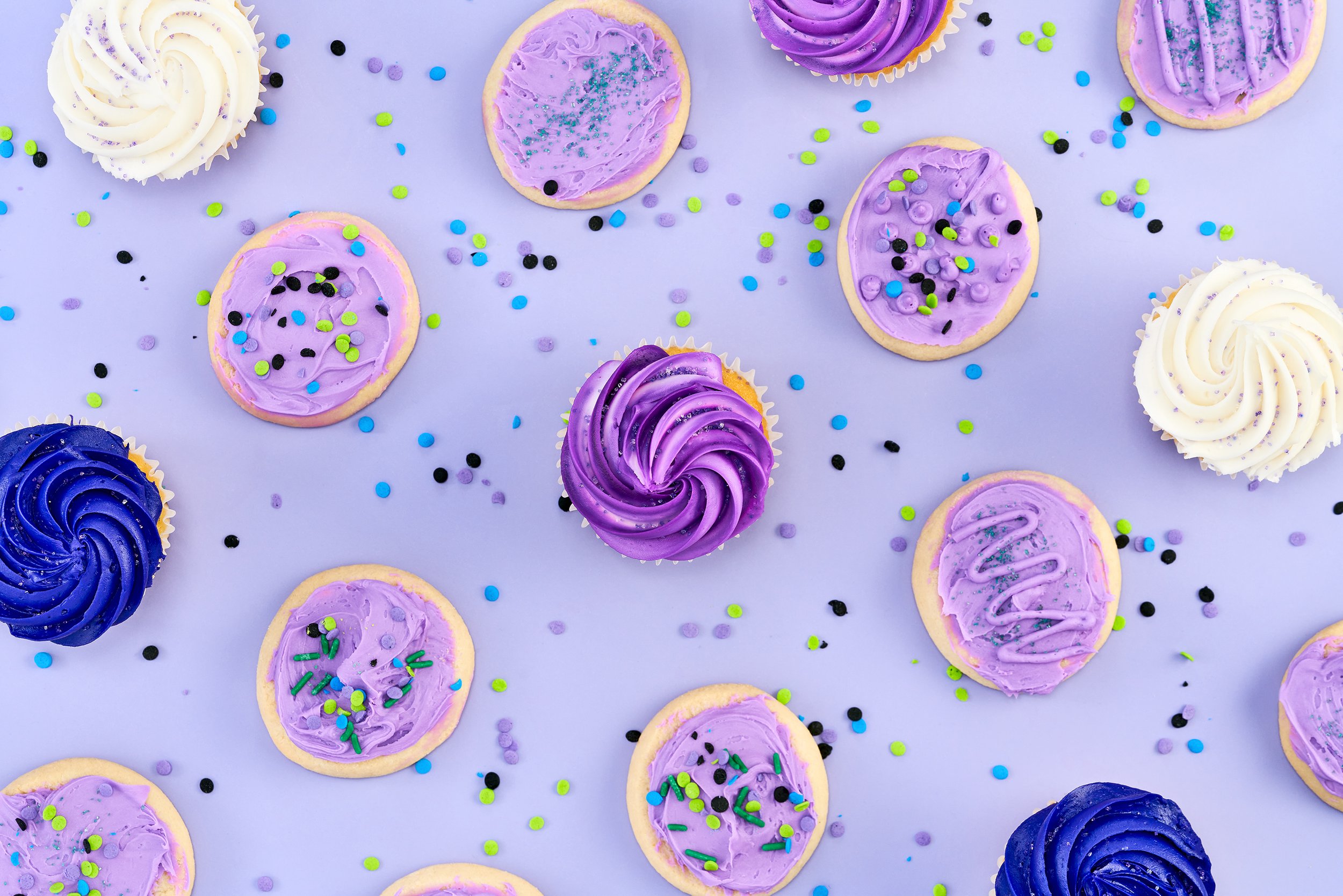 Purple, white and blue cupcakes and cookies, overhead, studio, food photography