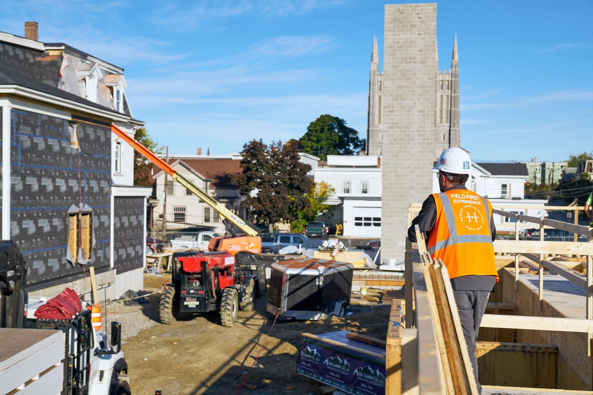 A supervisor looks out at a job site from the second story of a new building. Construction  photography.