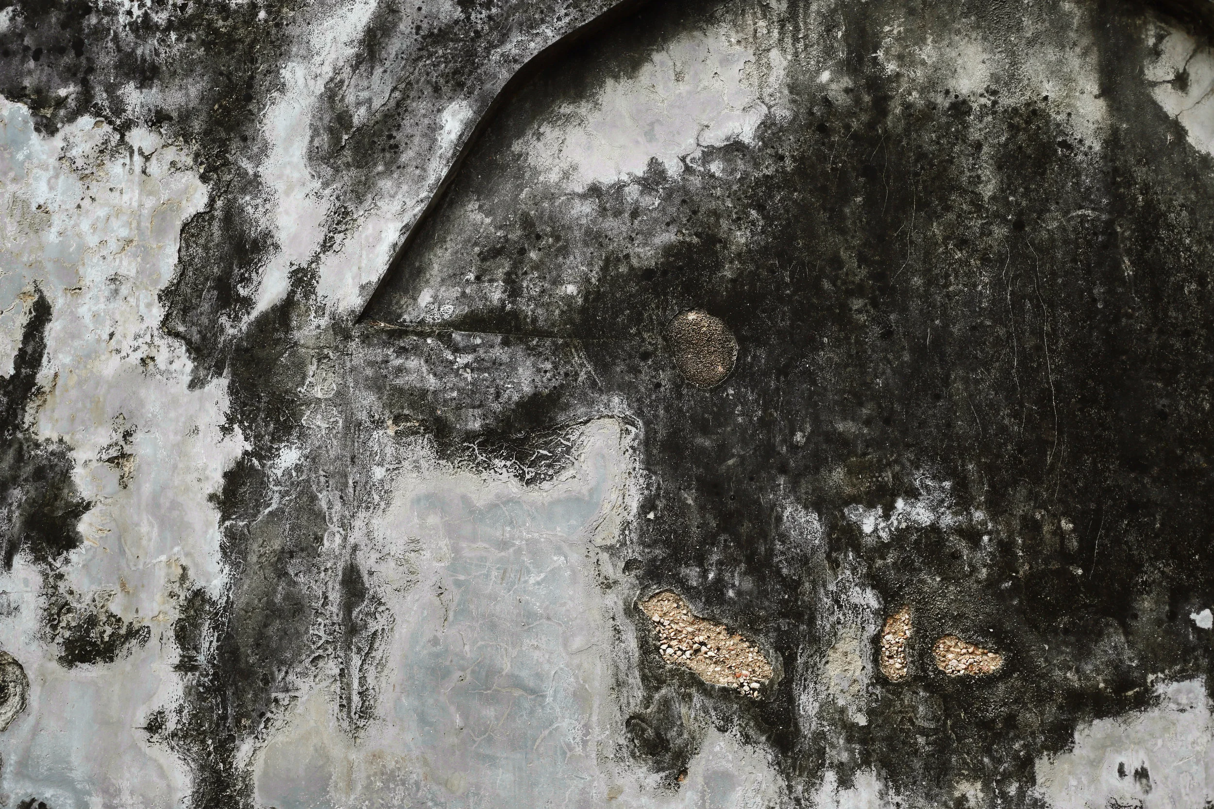 Layers of age on a wall aside the water front