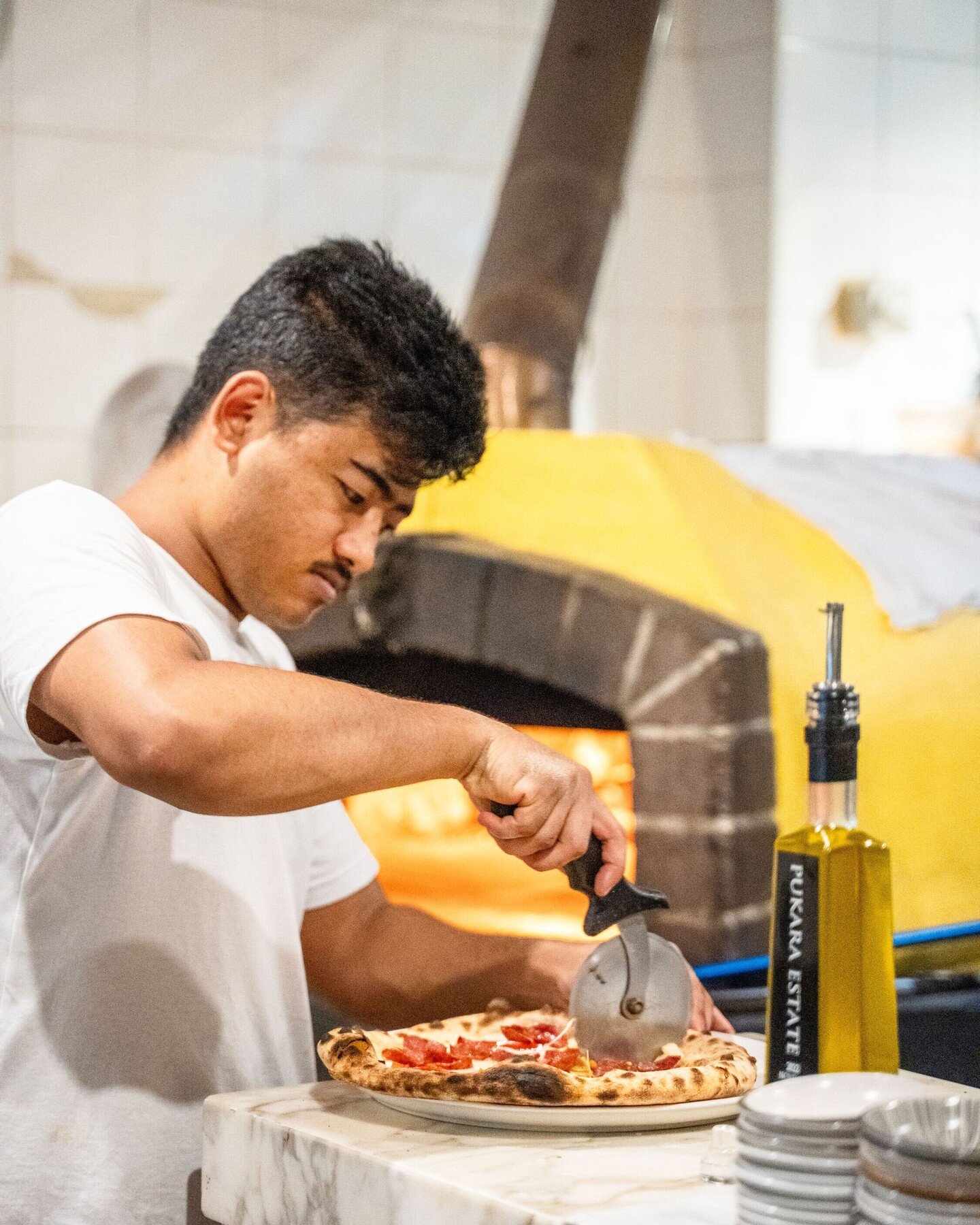 Slice, slice baby! 🍕 Our chef is busy making sure every piece is perfect. 
Come by for a slice of this cheesy goodness! 

#PizzaLovers #FreshlyBaked #PizzaTime