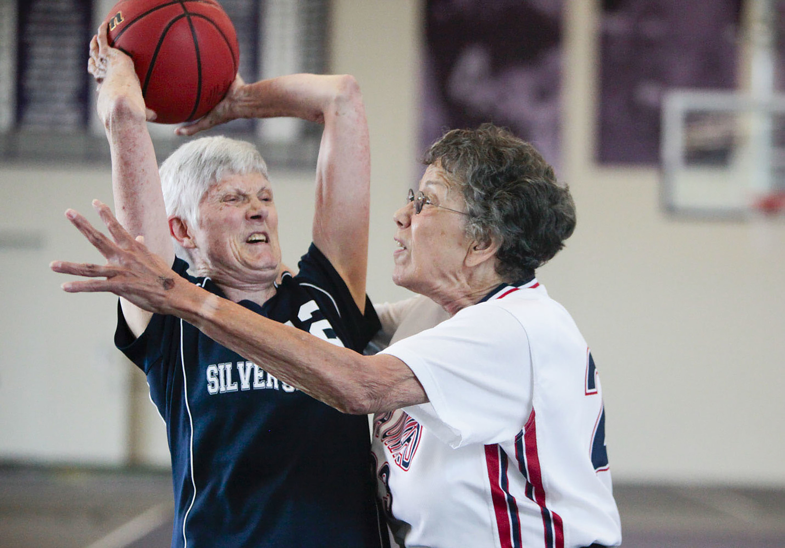  Kay Poole (left) of the Silver Spirits attempts to pass the ball as Jacqueline Stephens (right) of NOVA United Classics blocks her during the National Senior Games basketball competition. This competition took place at the St. Thomas University Bask