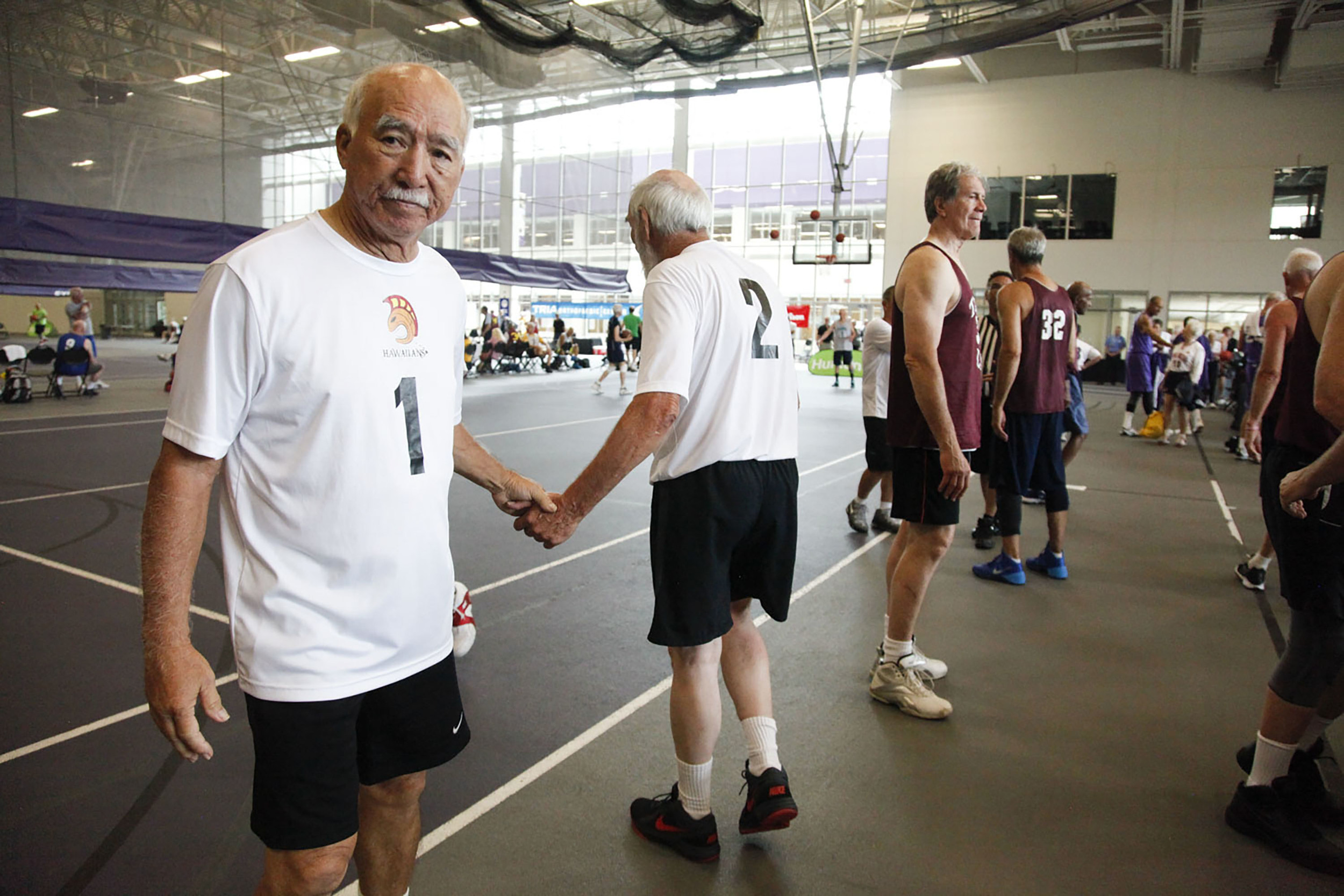  Wayne Kihune (left) and Jerry Schletzbaum (right) of the Hawaiians shake hands after a game against Taylor Law during the National Senior Games basketball competition. This competition took place at the St. Thomas University Basketball Court in St. 