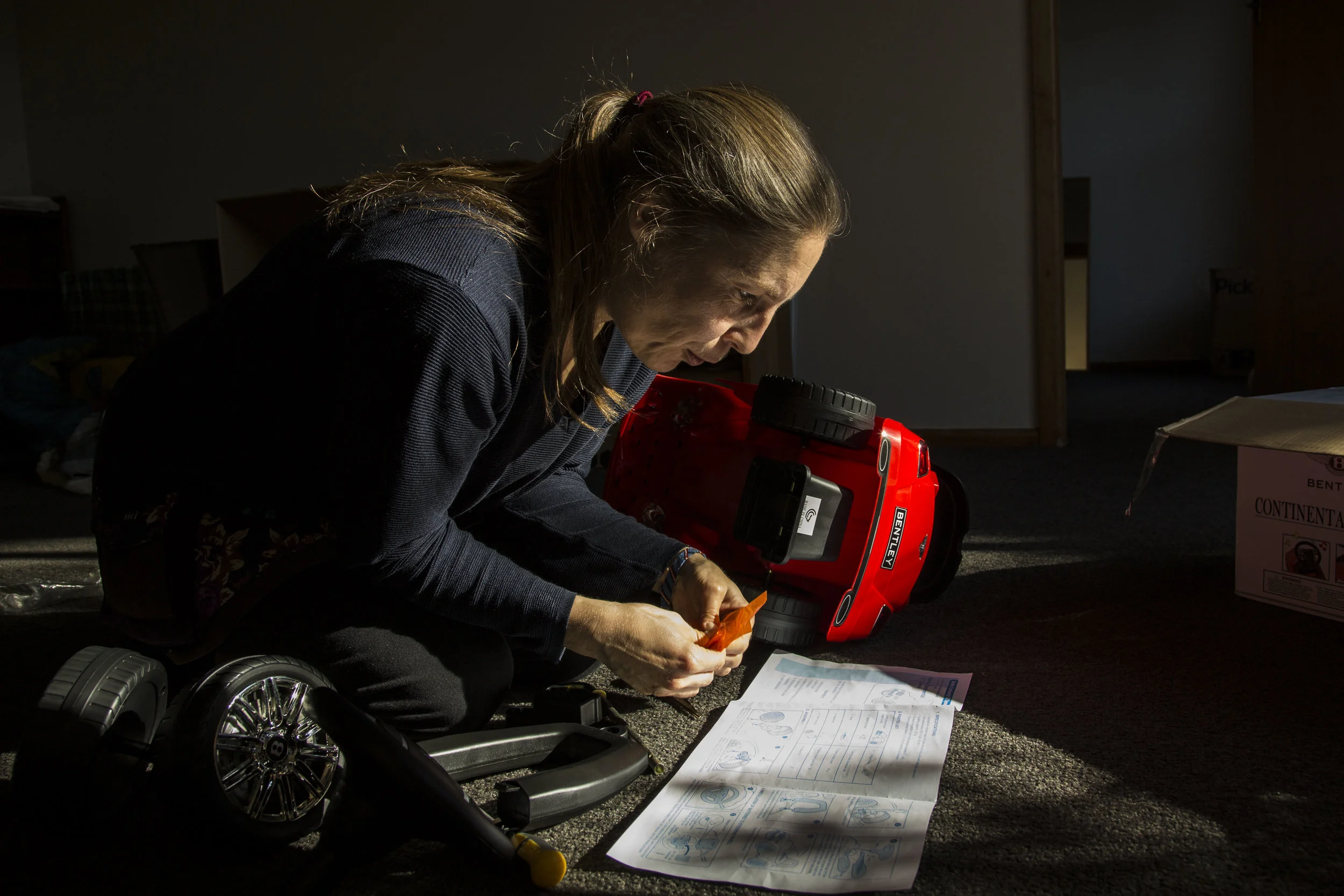 Olli Ricken puts together a toy Bentley for her boyfriend, Neil Wooten, as a joke in her Christchurch, NZ home. 