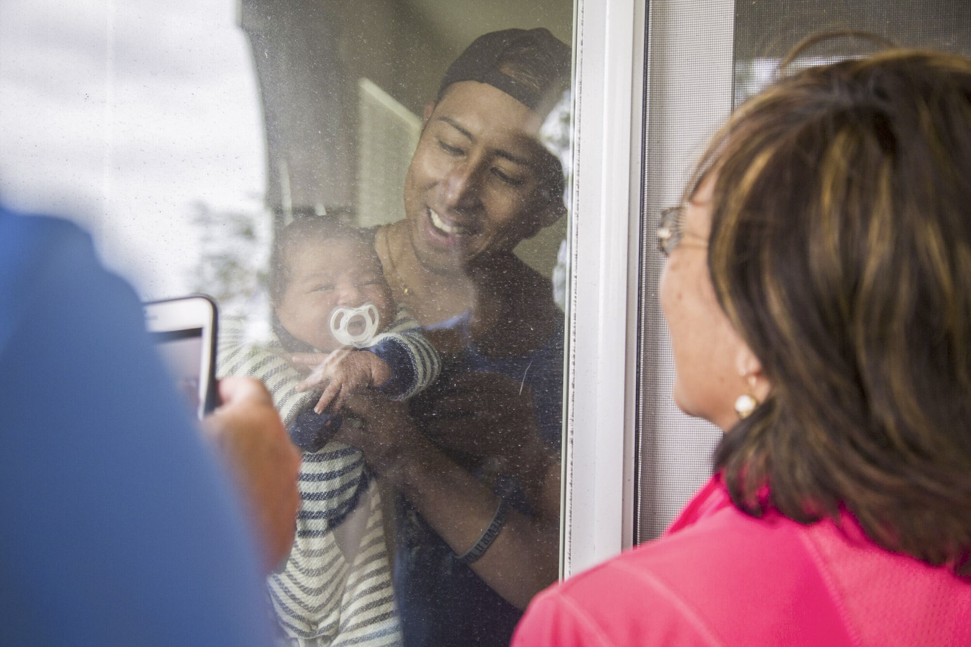  My parents look at my baby cousin, Zavian, for the first time through his home's sliding glass door in Ewa Beach. 