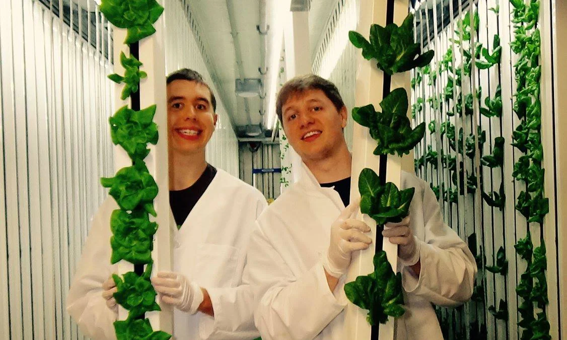 Zach and his brother Nic showing off some heads of hydroponic lettuce from their farm.