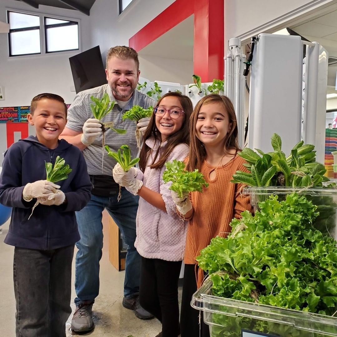 Three students and teacher with lettuce