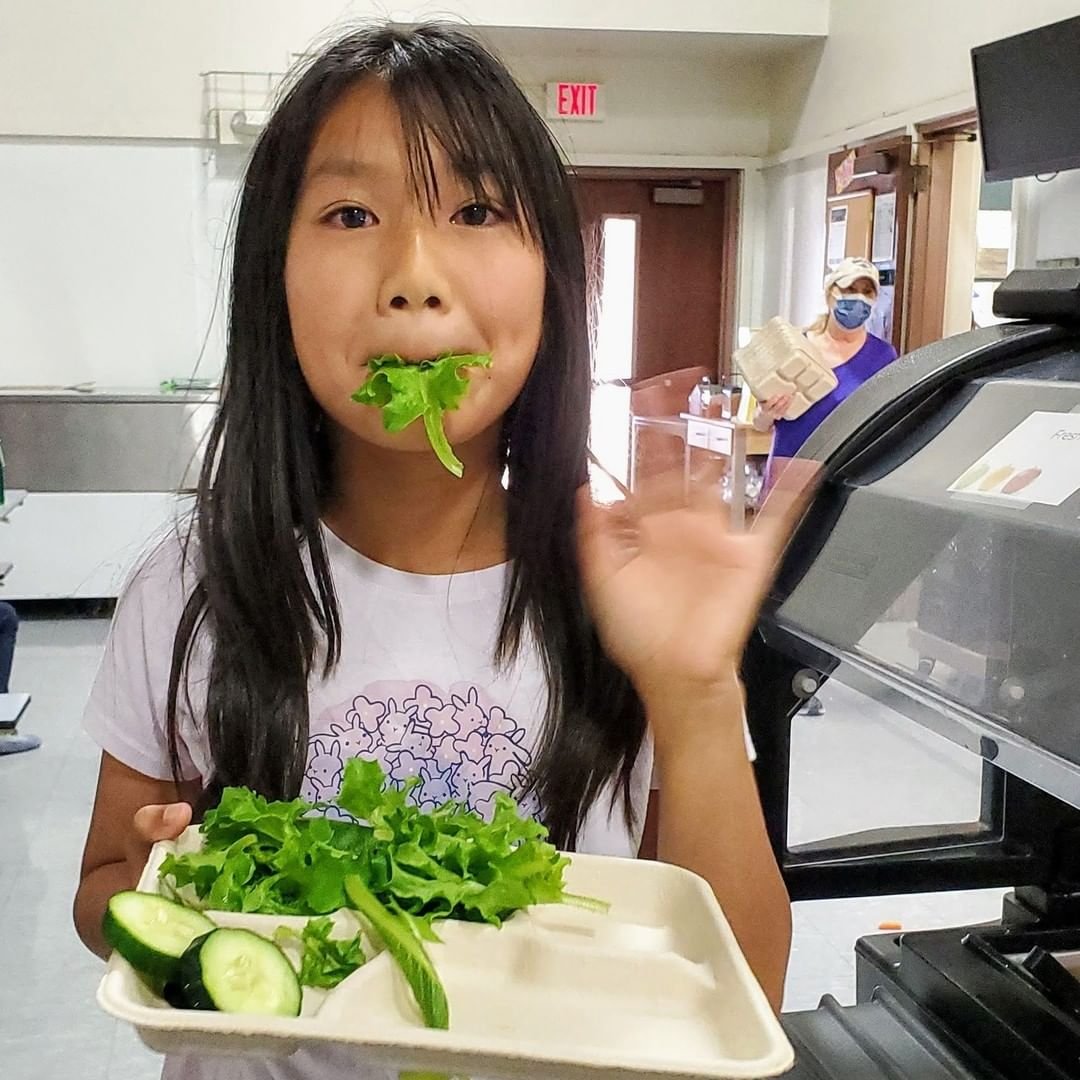 One student eats a mouthful of lettuce