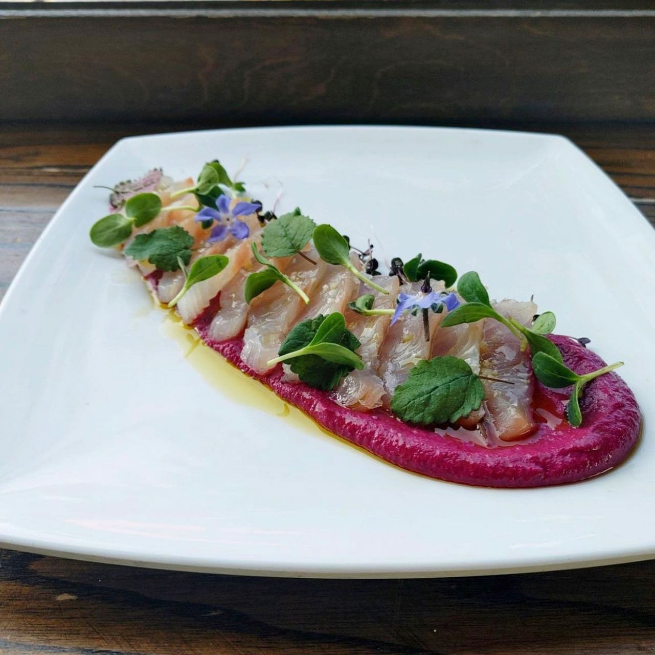 Rashimi with pink puree and small hydroponic leaves