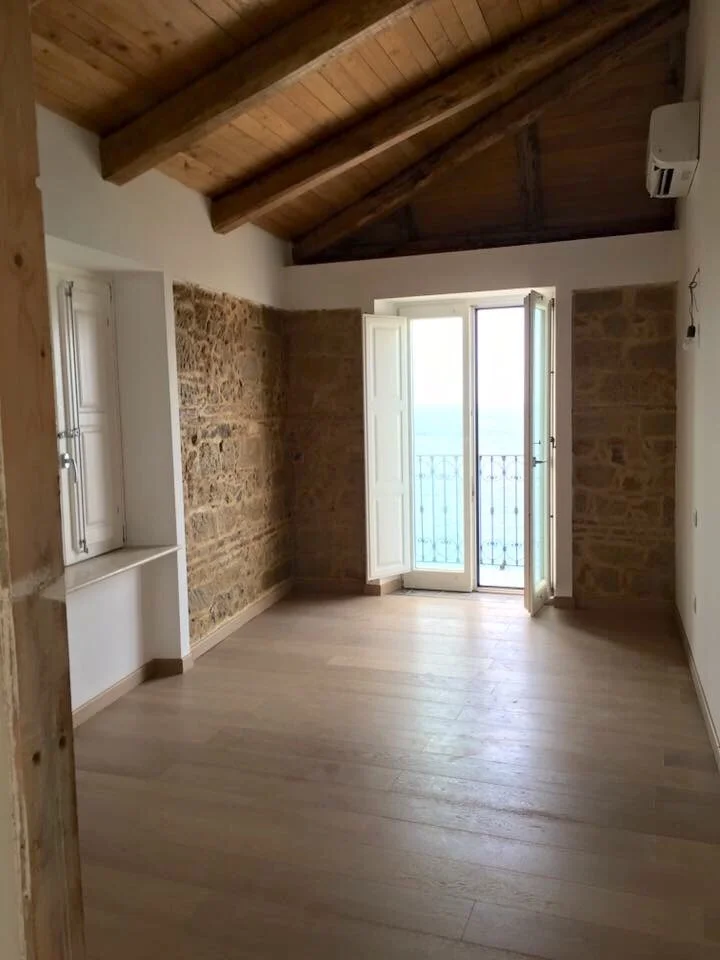 Dependance: The second bedroom with small balcony facing the sea and restored stone wall 