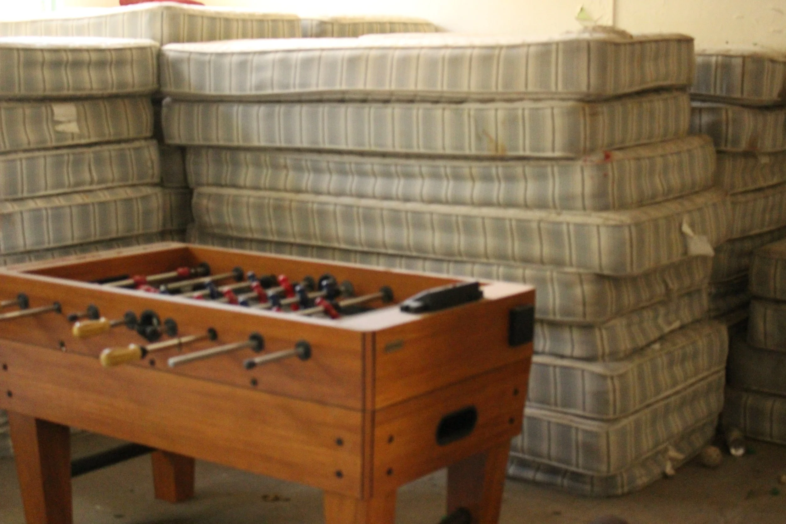  An abandoned foosball table and discarded mattresses. 