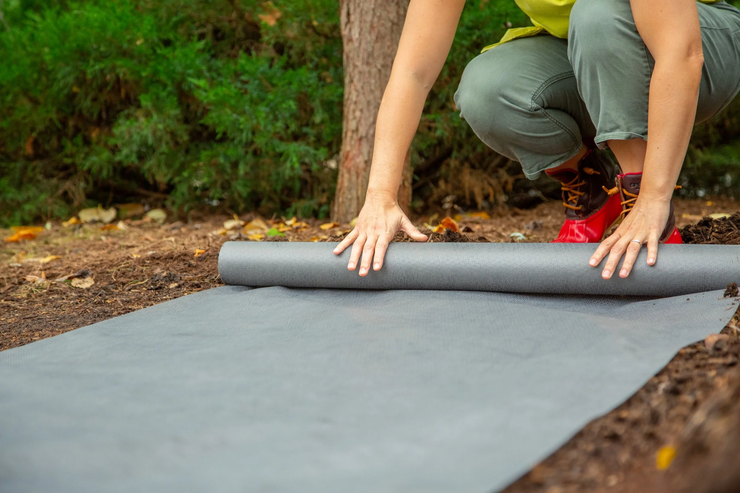 Gardener rolling out Gardien landscape fabric