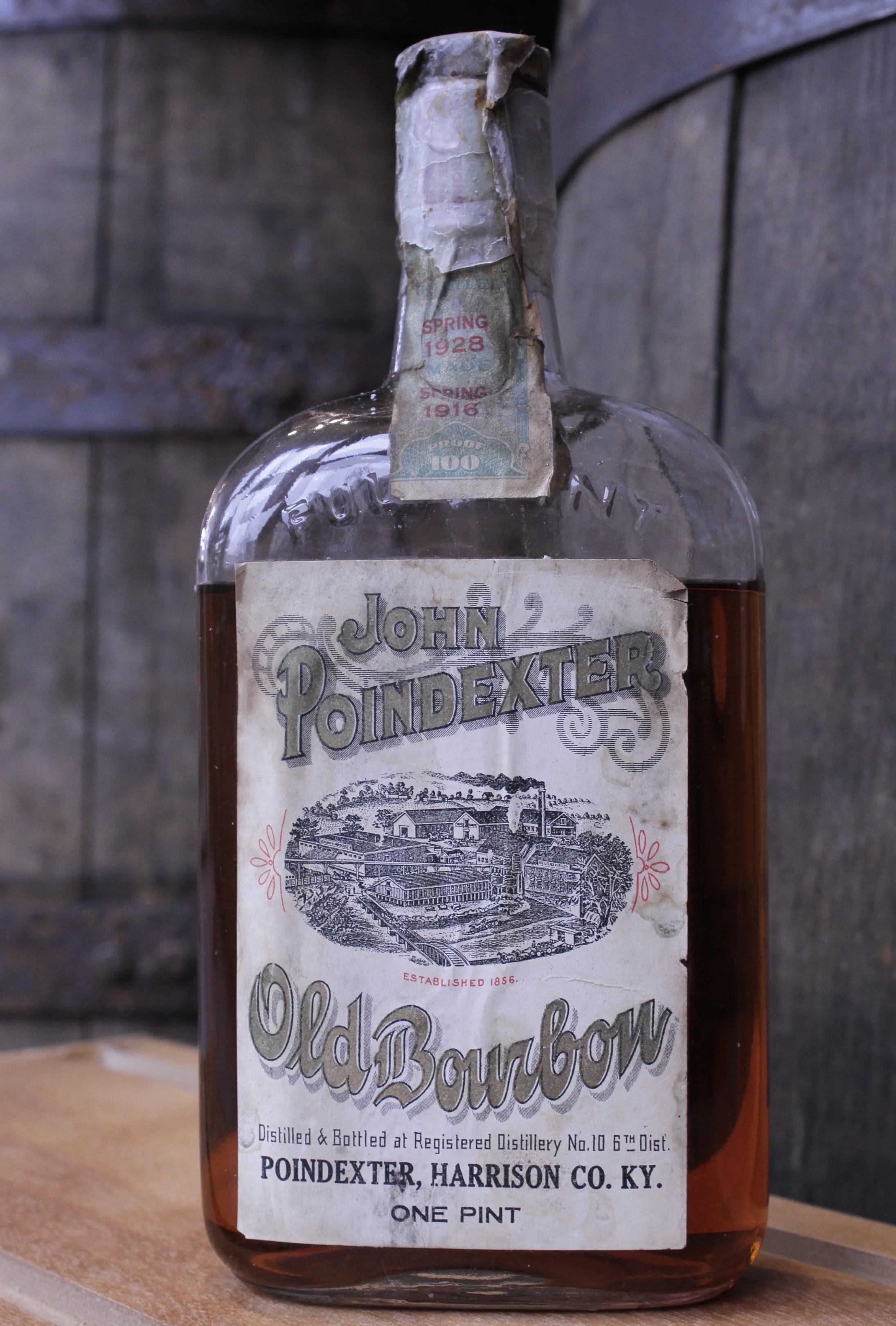 JOHN POINDEXTER OLD BOURBON About the Product One pint of Kentucky bourbon (100 proof), aged 12 years, bottled in bond. Distilled in spring 1916** by Wiglesworth Bros. Co. Bottled in spring 1928** by Joseph Wolf. Introduced by John Poindexter in the 1850s and later acquired by the Wiglesworth Bros. Co., this brand of sour mash bourbon remained in production until Prohibition. About the Distillery 6th Dist., RD #10, Wiglesworth Bros. Co. (1869 – 1919). Harrison County, Kentucky, USA. Located on the South Fork of the Licking River four miles northwest of Cynthiana, this distillery was built in 1856 by John Poindexter. In 1869 the Wiglesworth family acquired it, tore it down and rebuilt it. By 1910 the mashing capacity had been increased to 300 bushels per day, and there were three bonded warehouses with a storage capacity for 20,000 barrels. In the late 1910s the officers were J. M. Wiglesworth, president and W. T. Wiglesworth, secretary-treasurer. Products included Old G. W. Taylor, Poindexter Bourbon, and Wiglesworth Bros. Sweet Mash. The distillery closed at Prohibition. In 1924 all the whiskey in storage was transferred to the concentration warehouses of James E. Pepper & Co., a facility in Lexington that had been leased in 1907 for 20 years by Joseph Wolf of Chicago, where it was bottled for medicinal spirits.