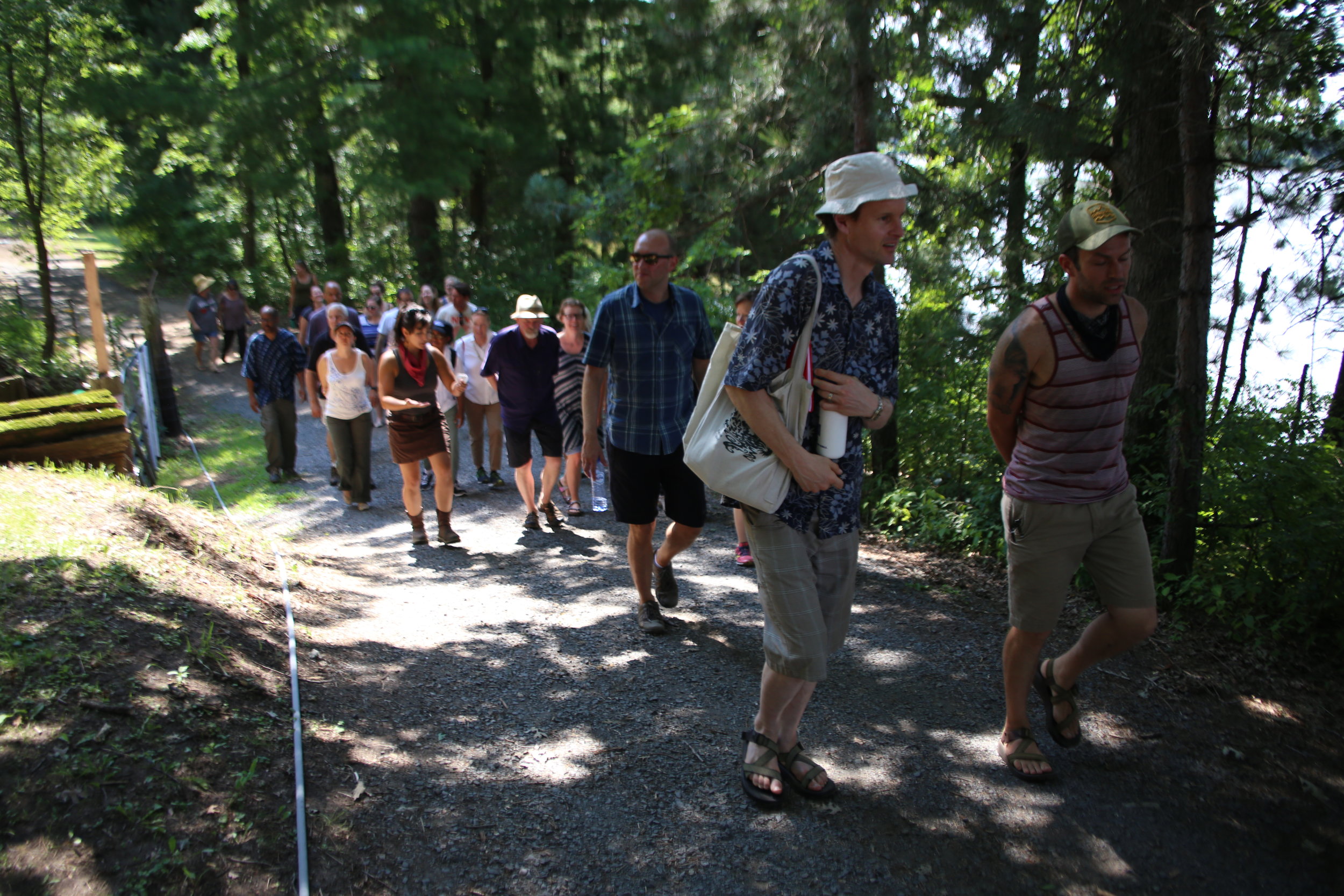 The HECUA group walks through the forest on their way back to the barn, chatting about what they just saw and learned about the mitigation of invasive species in restorative agriculture.