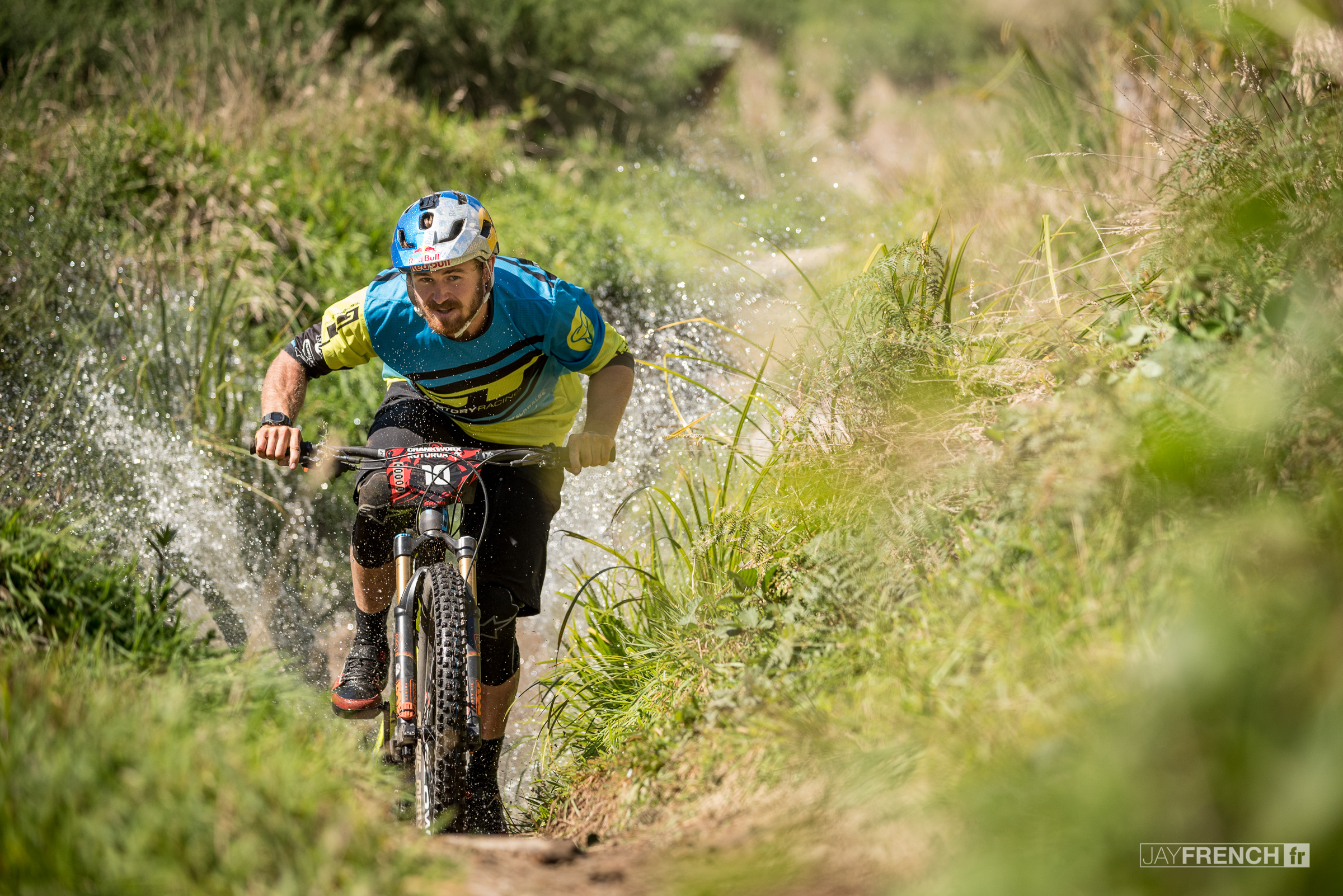 Brook MacDonald splashes through the creek at the bottom of stage 5.